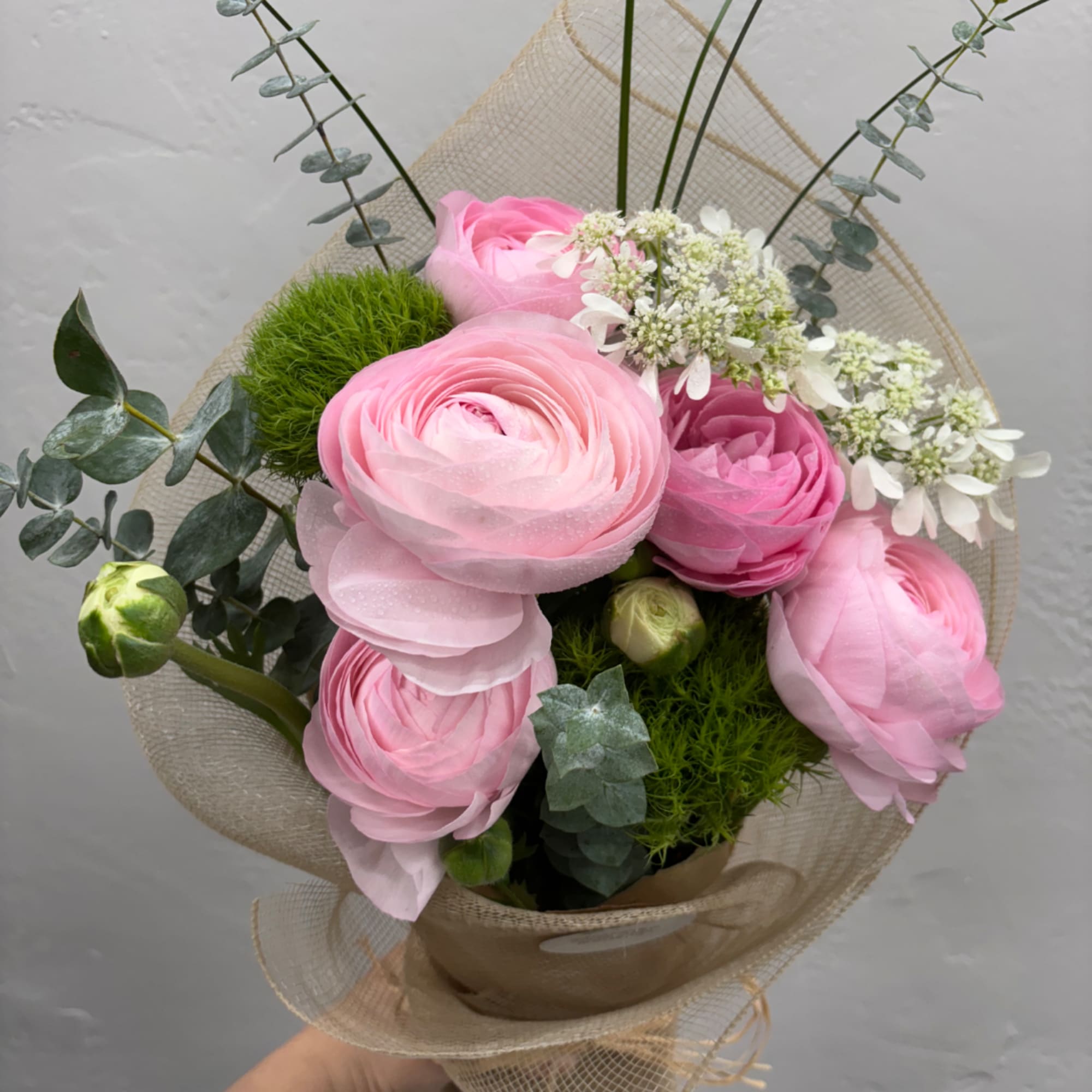 Pink ranunculus bouquet with eucalyptus and white filler flowers