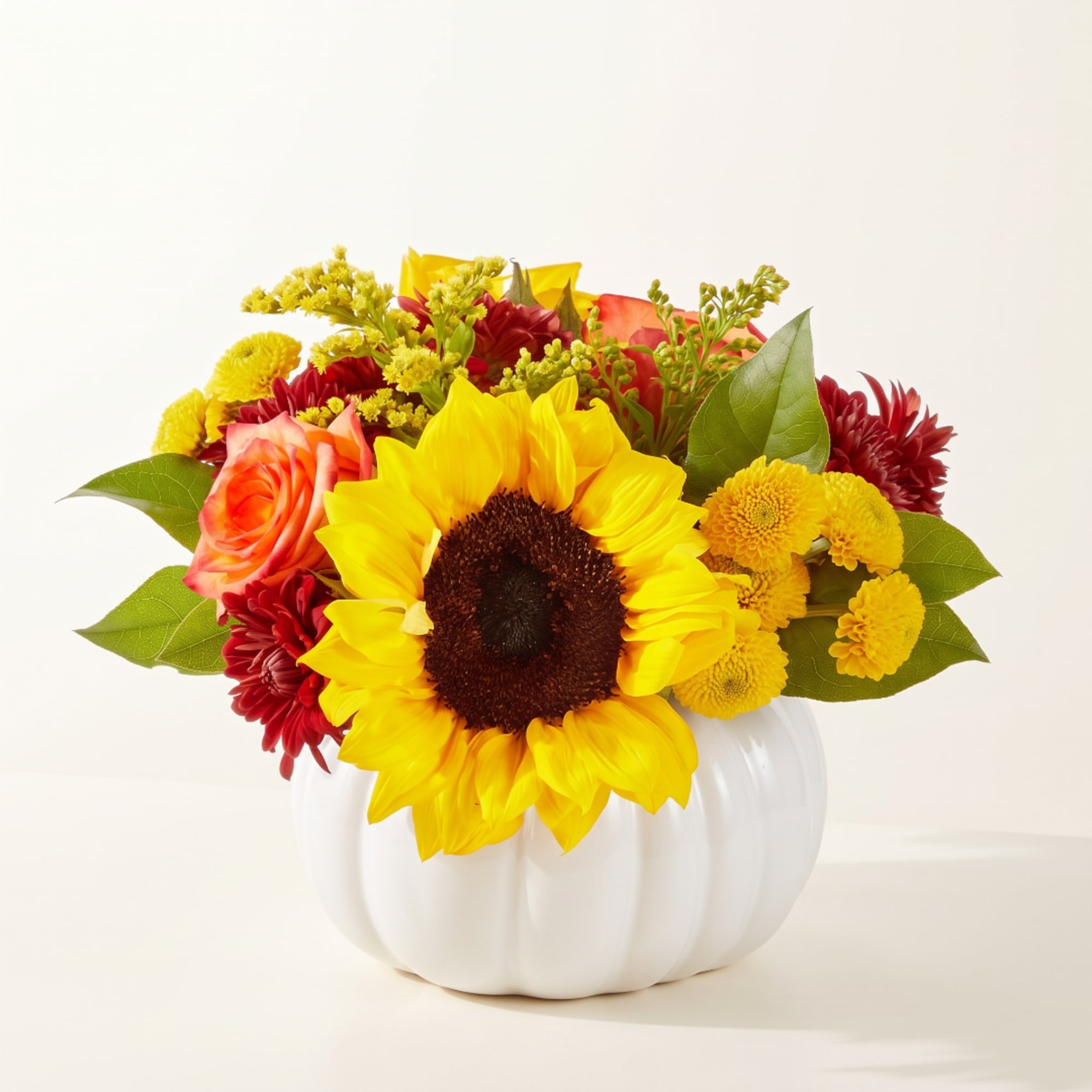 Sunflower and mixed flower arrangement in a white pumpkin vase