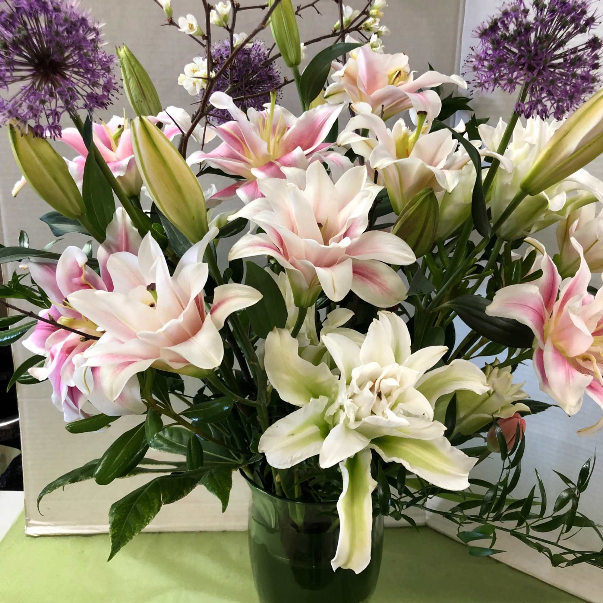 Large white lilies-some brushed with soft pink and green-meet clusters of deep
