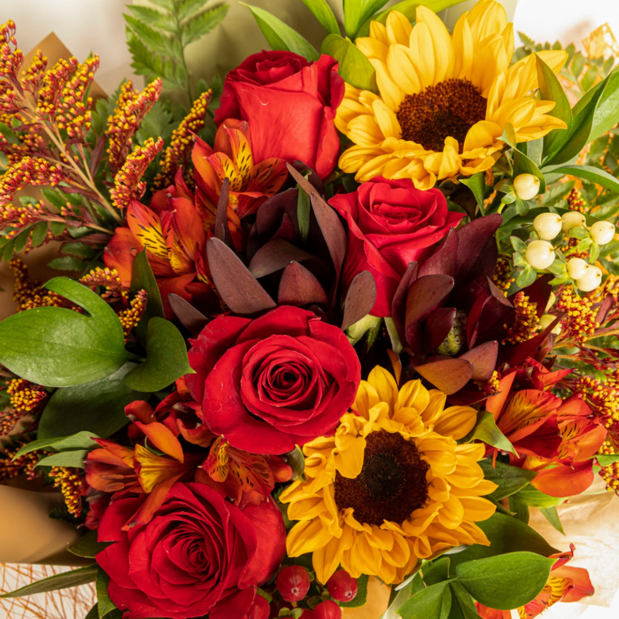 Bouquet of red roses and yellow sunflowers with orange flowers