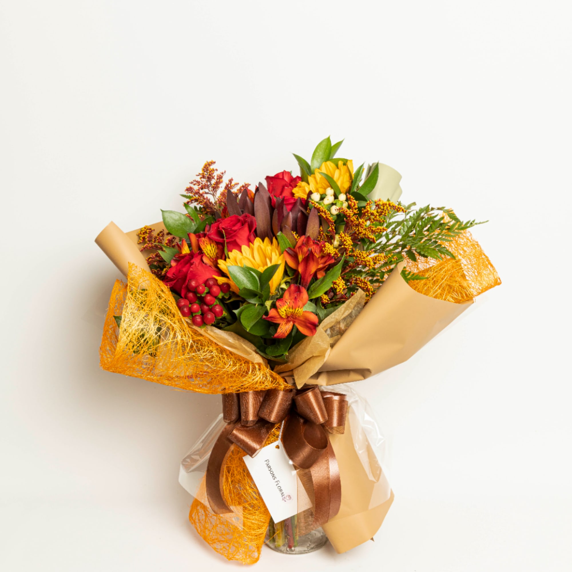 Bouquet of red and yellow flowers wrapped in tan paper with a brown ribbon