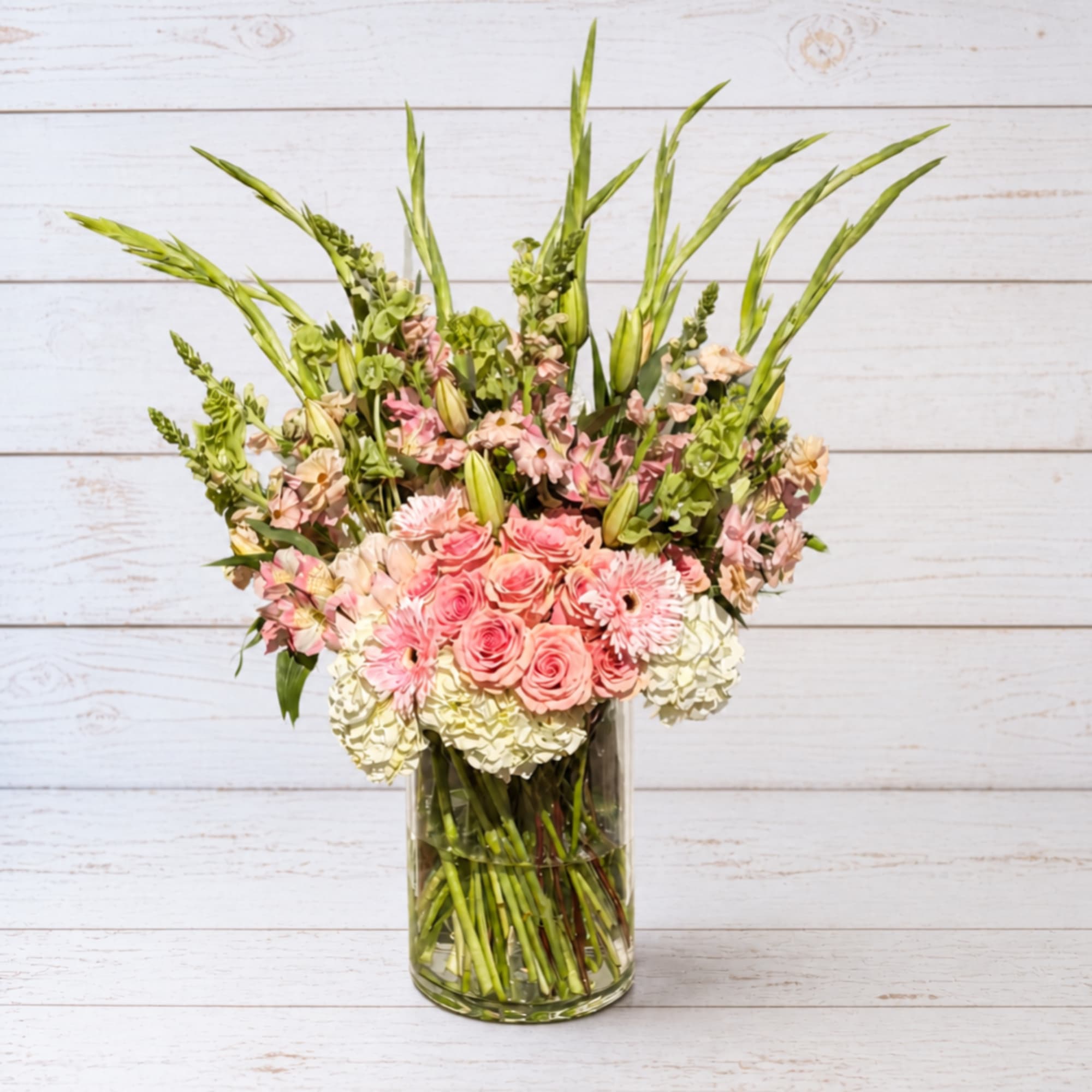 Pink roses and white hydrangeas in a clear glass vase