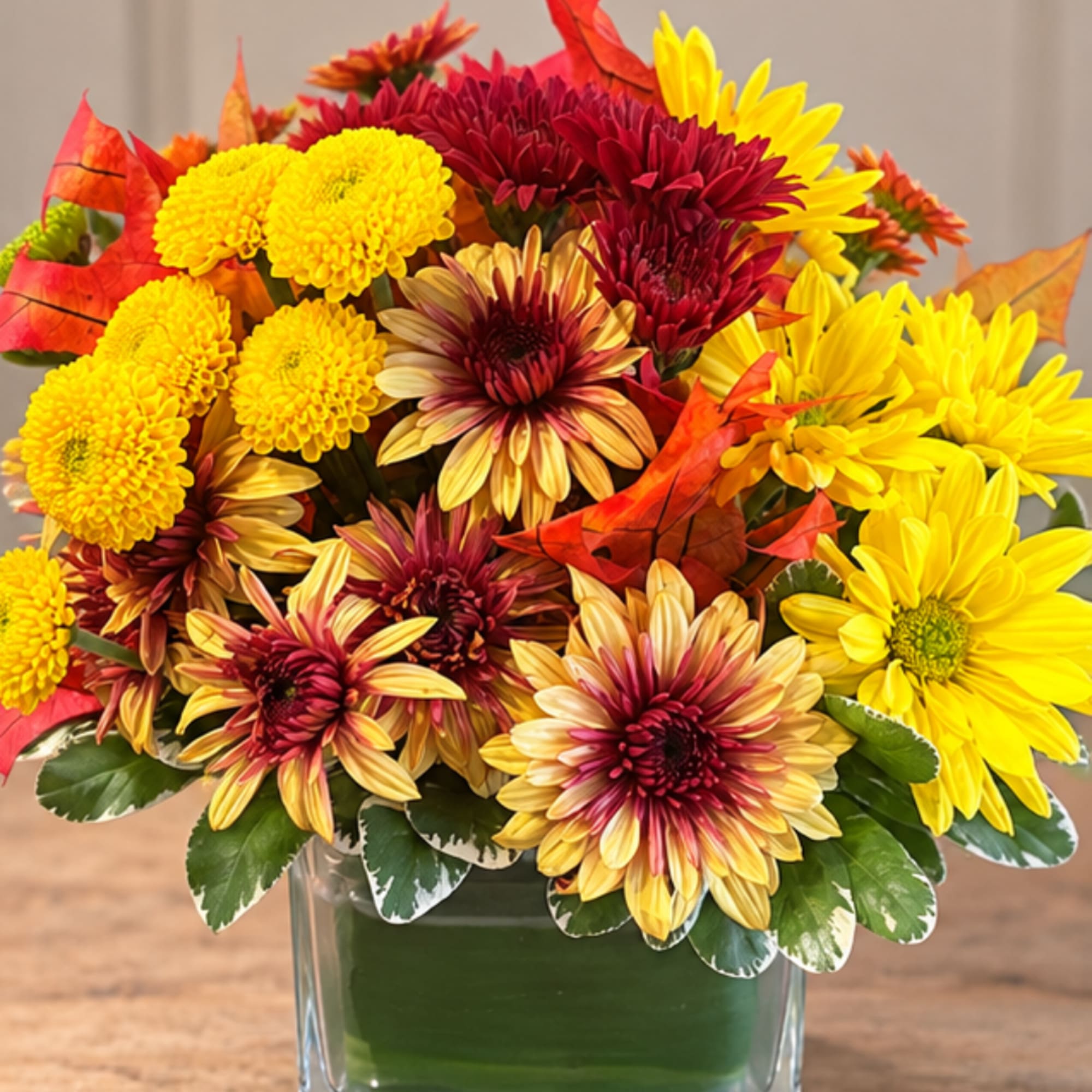 Bouquet of yellow and burgundy chrysanthemums in a clear glass vase