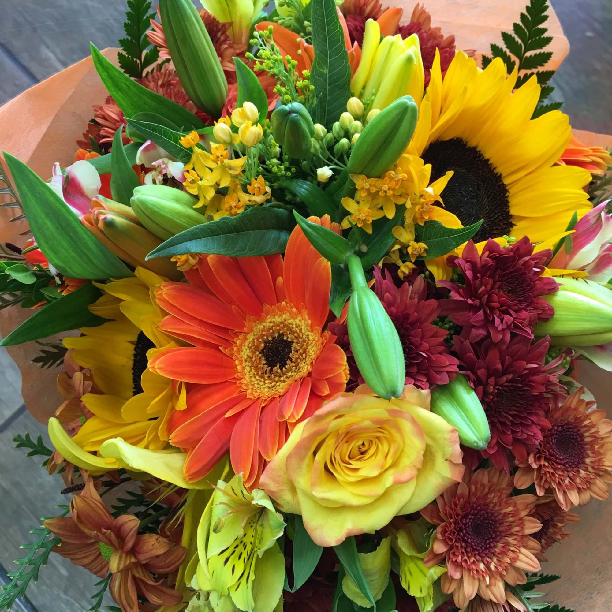 Hand tied bouquet consist of assortment of fall flowers wrap in tissue, photo 2 of 2