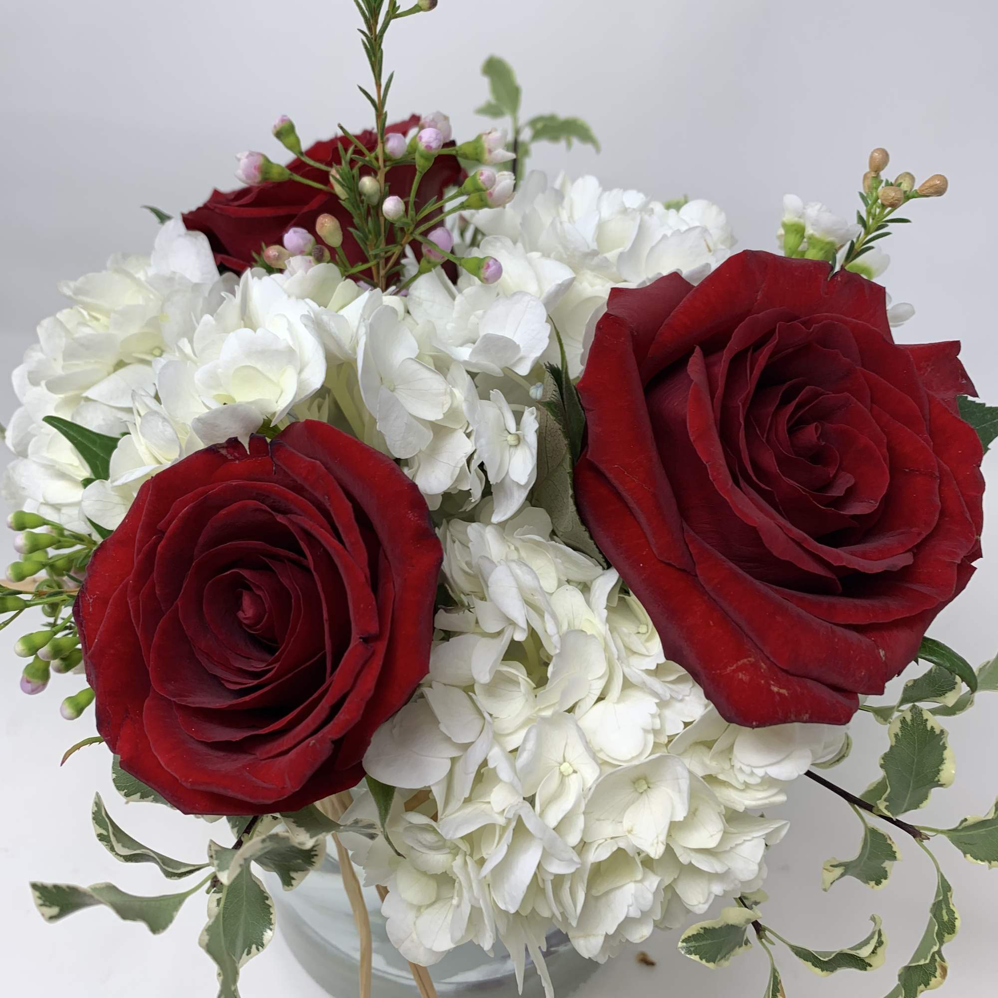 Floral arrangement consisting of red roses, hydrangeas and foliage. 

*NOTE: Roses can, photo 2 of 2