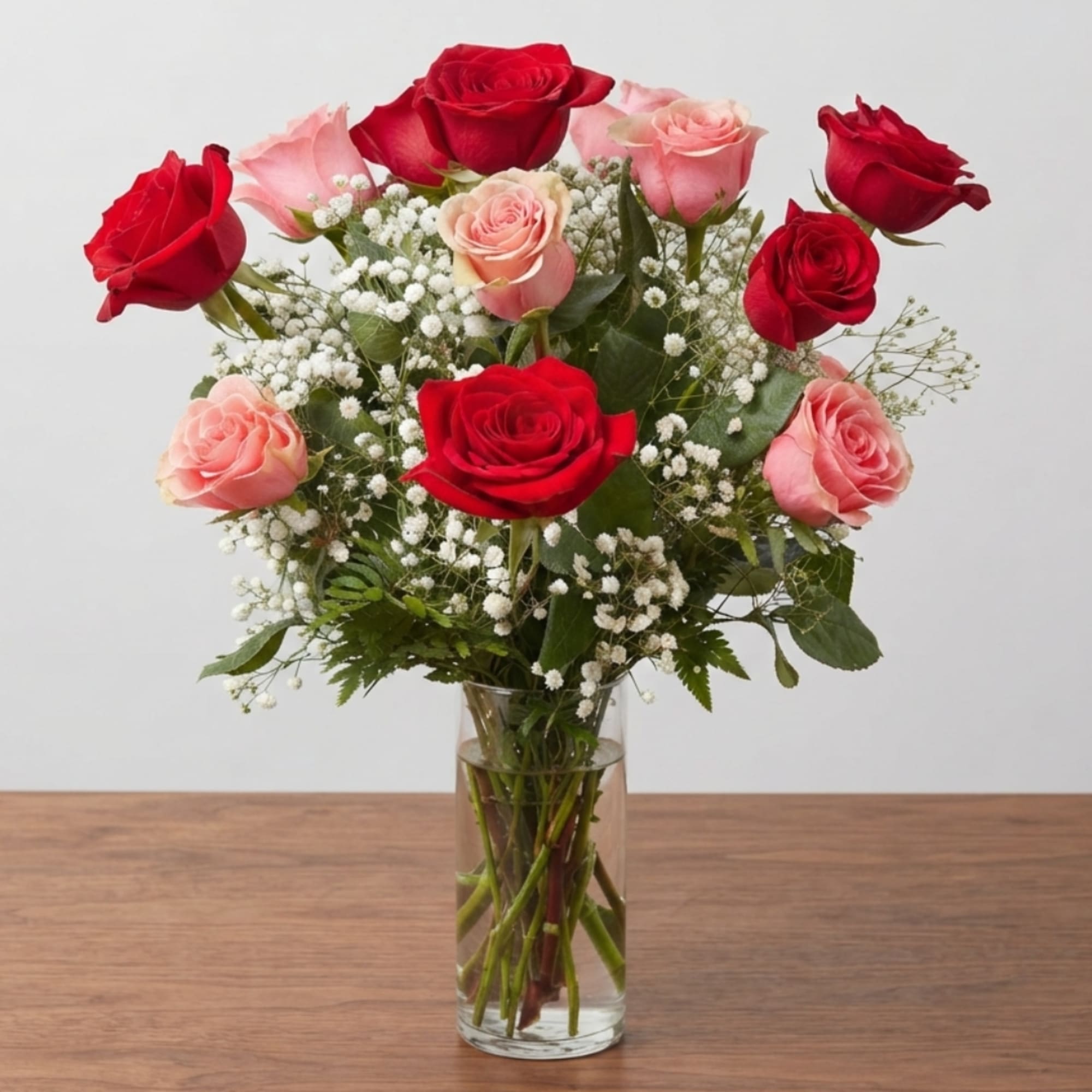 Bouquet of red and pink roses in a clear glass vase