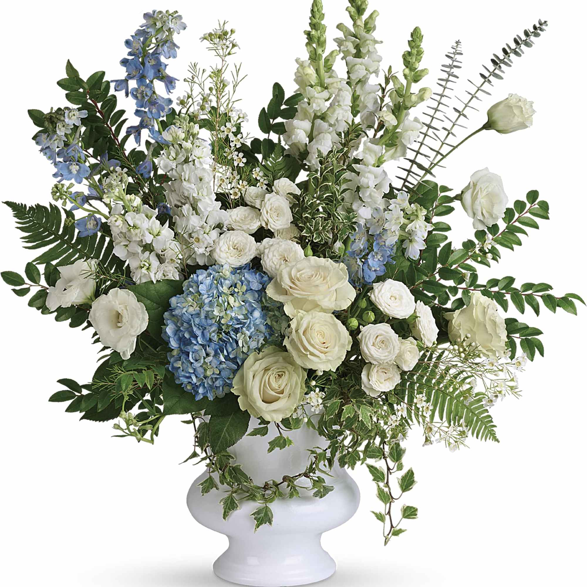 White and blue floral arrangement in a white pedestal vase