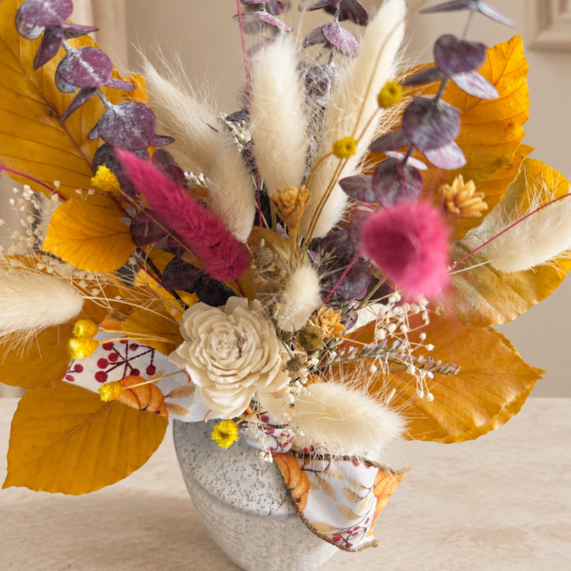 Autumn arrangement with dried flowers and a speckled ceramic vase