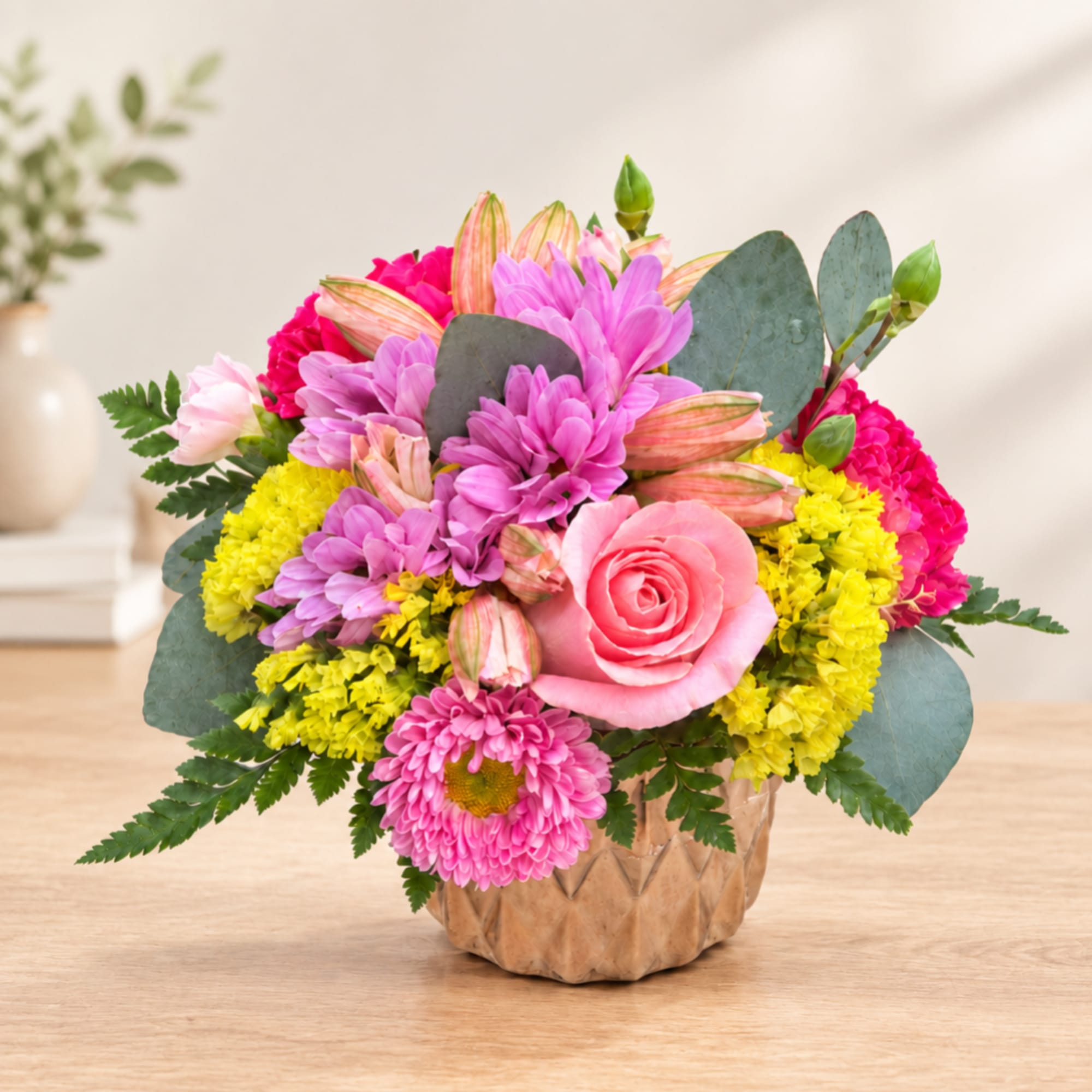 Pink and yellow mixed flower arrangement in a textured vase