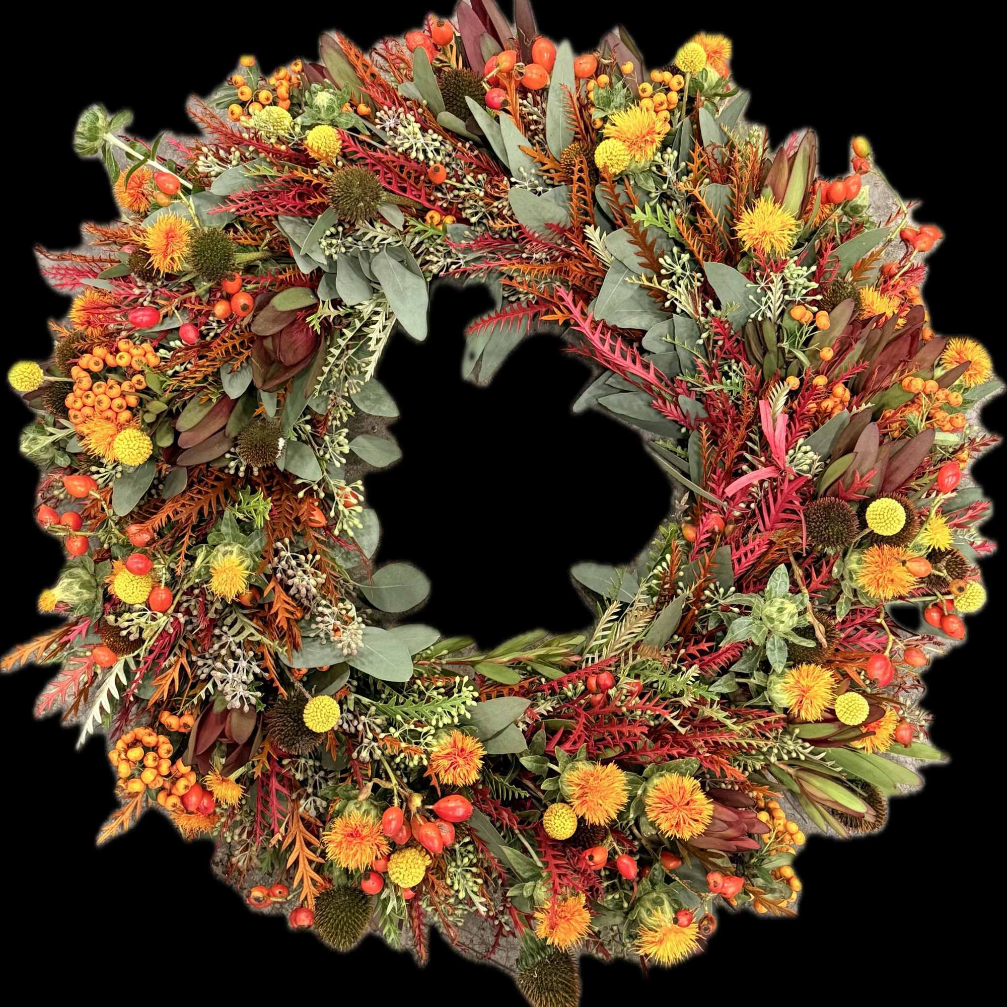 Autumn wreath with orange and yellow flowers and mixed foliage