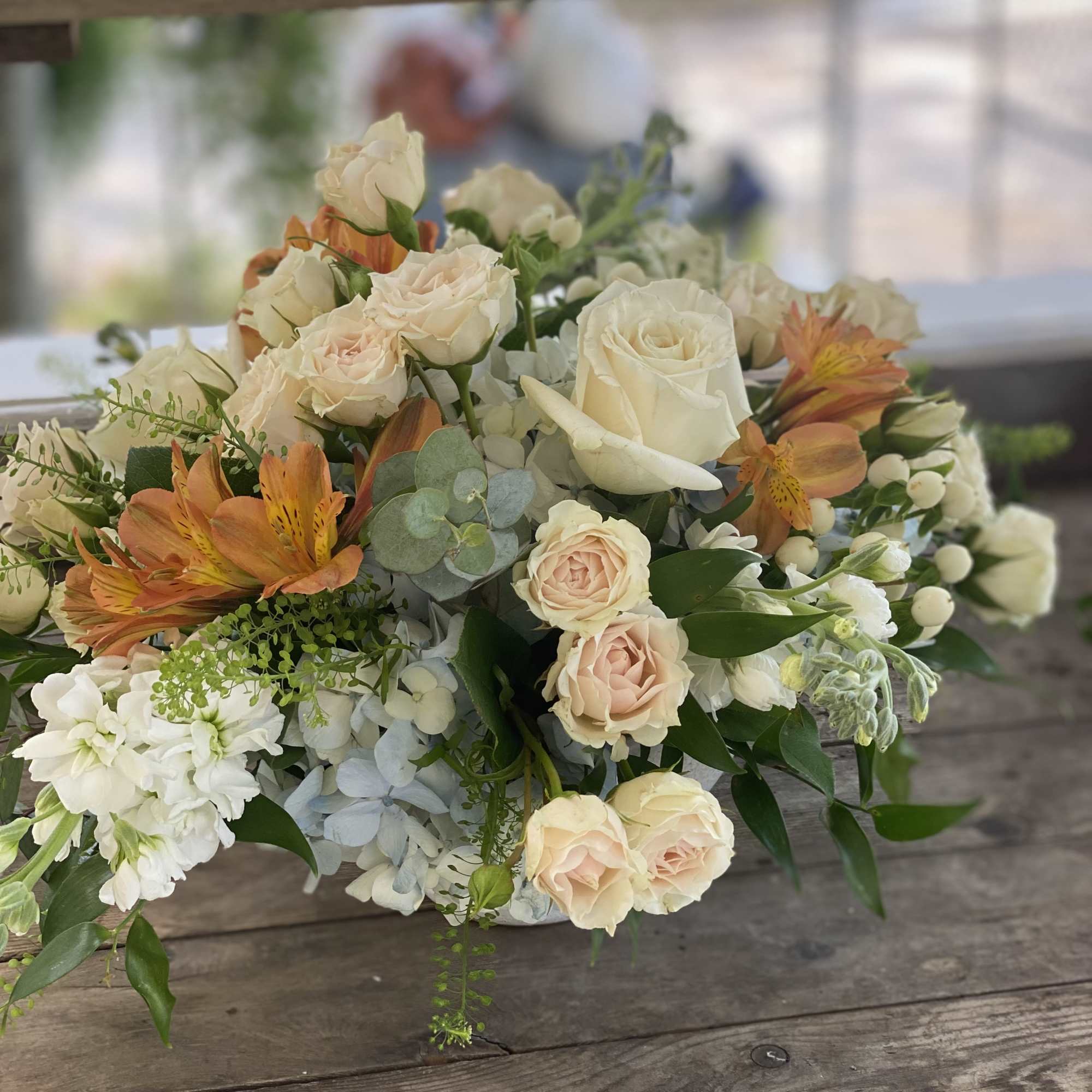 Cream and peach rose bouquet with white blooms in a low arrangement