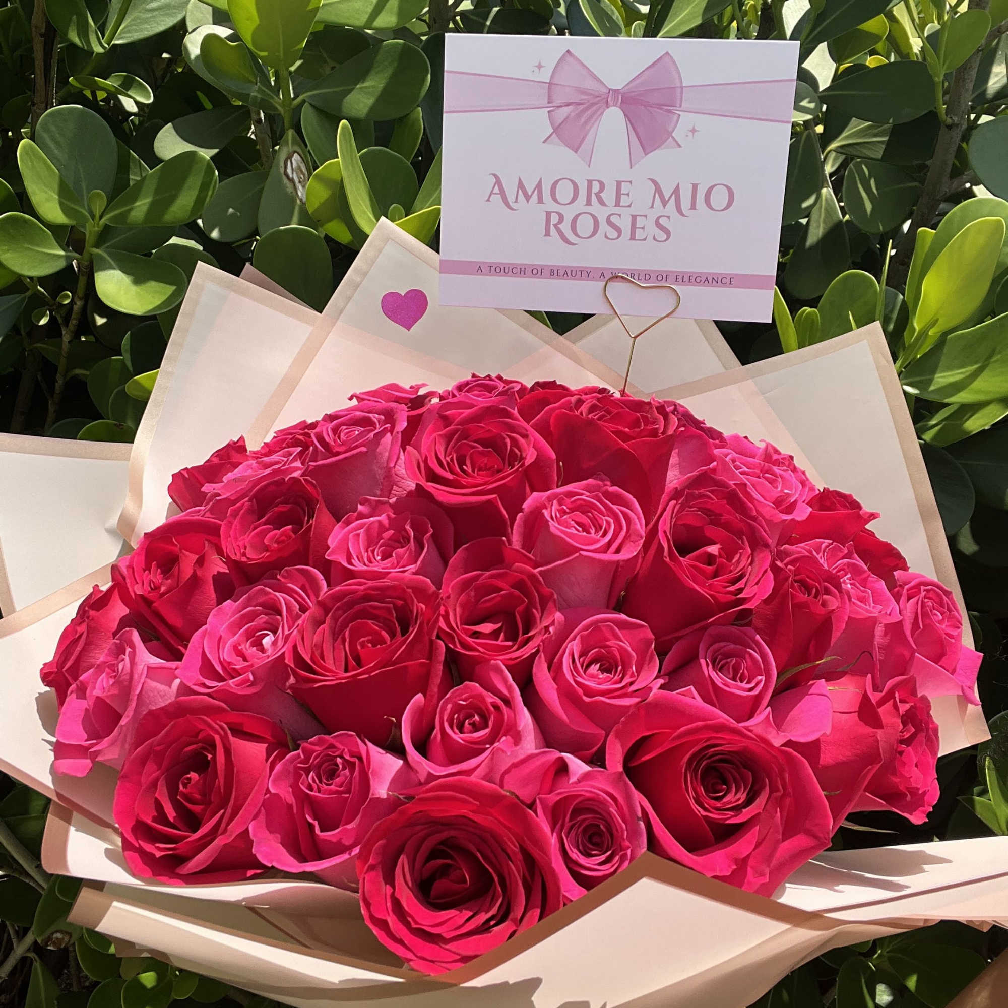 Bouquet of hot pink roses wrapped in pale paper