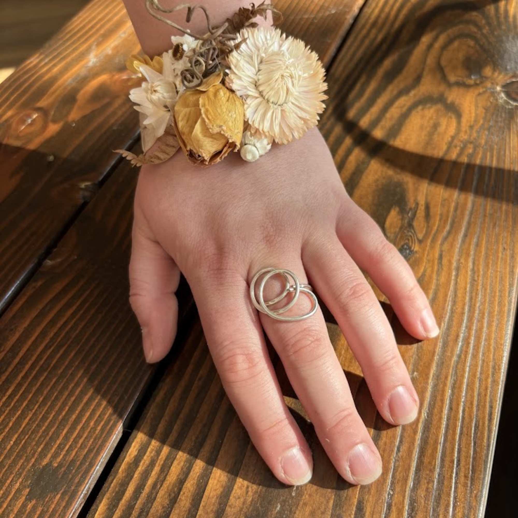 Dried flower wrist corsage on a hand
