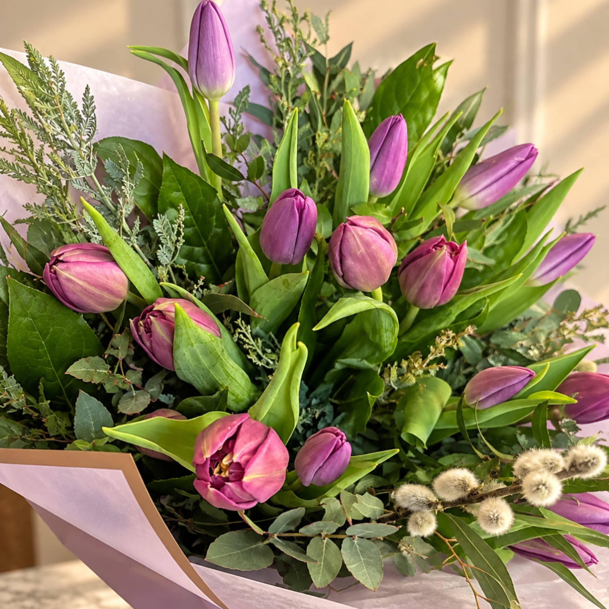 Bouquet of purple tulips with mixed greenery and lavender wrapping