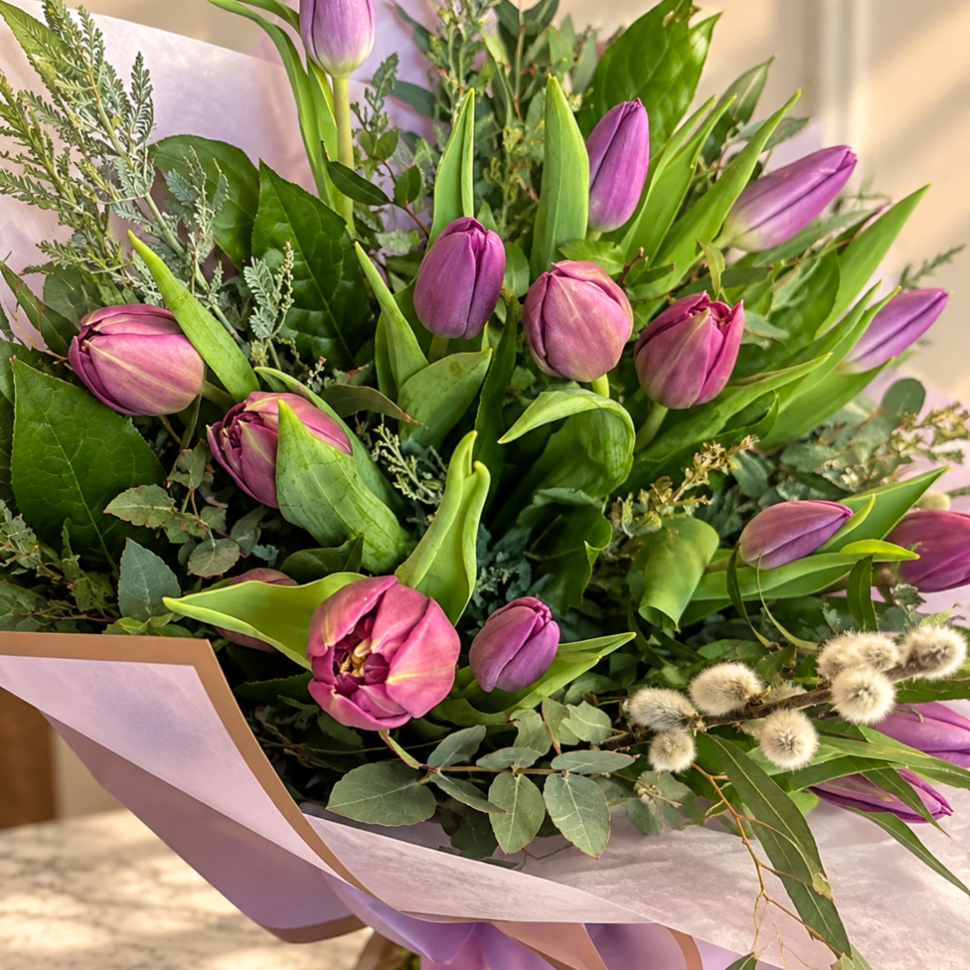 Bouquet of purple tulips wrapped in lavender paper