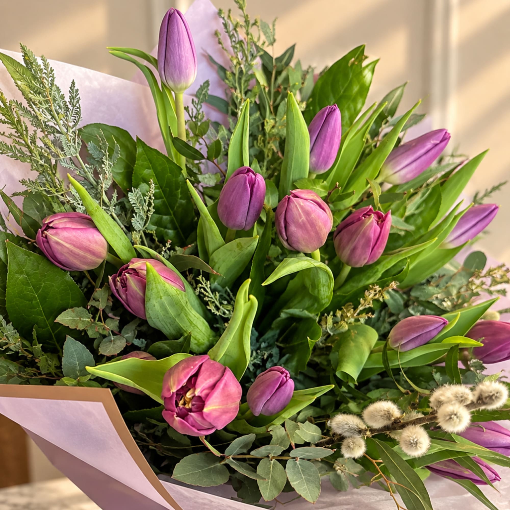 Bouquet of purple tulips wrapped in lavender paper