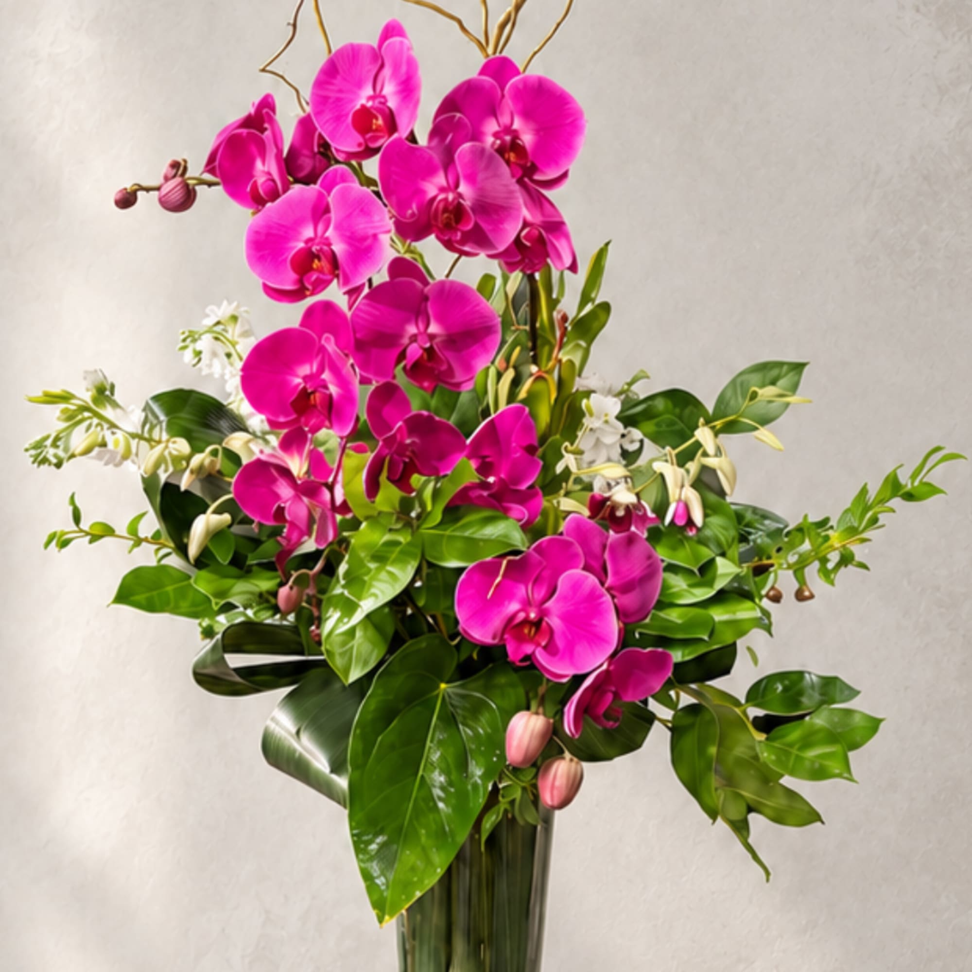 Tall arrangement of bright pink orchids in a glass vase