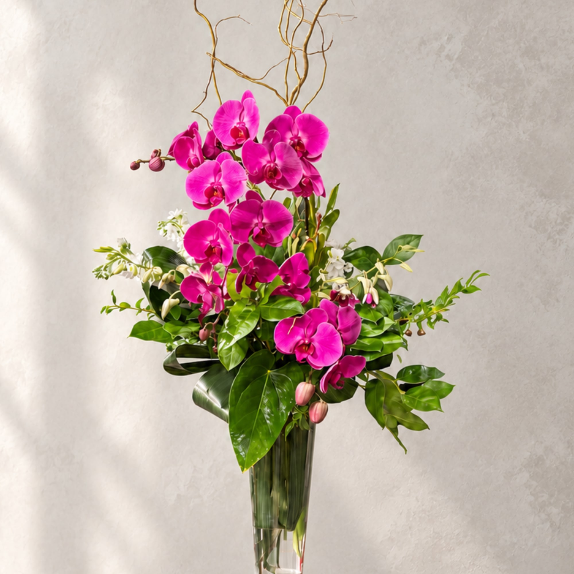 Tall arrangement of bright pink orchids in a clear glass vase, photo 2 of 3