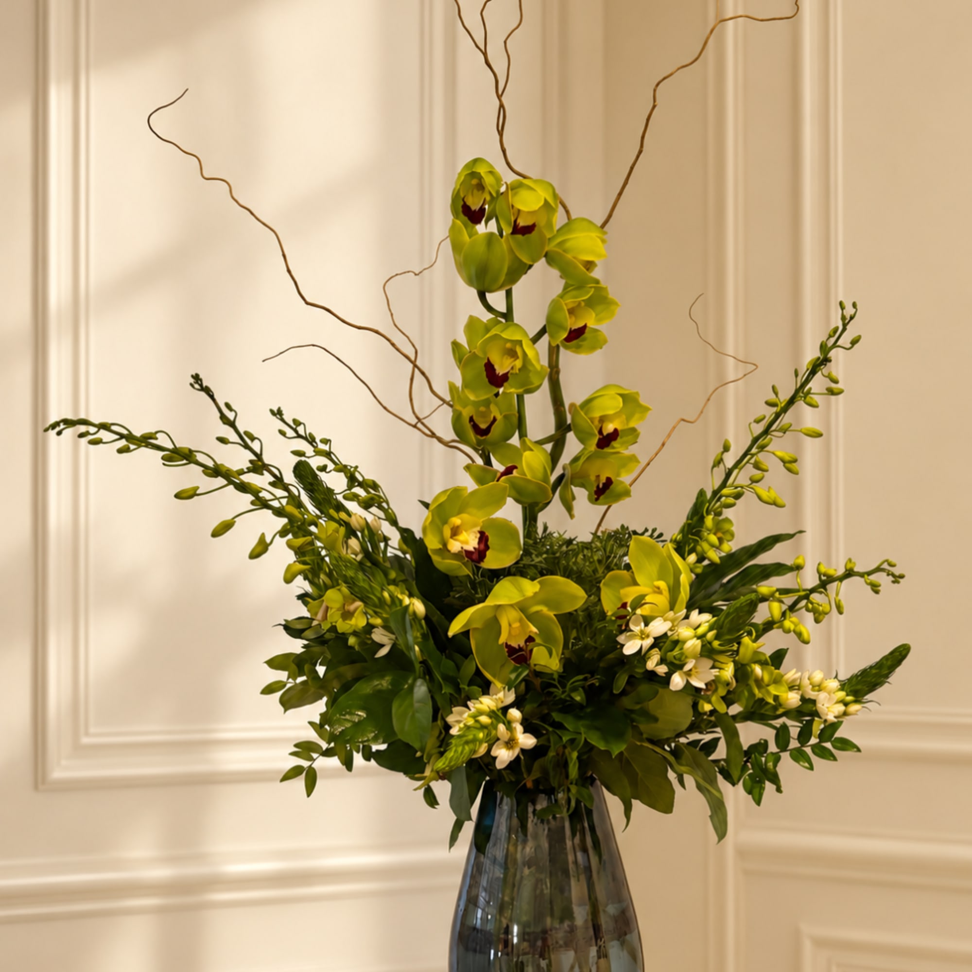 Tall green orchid arrangement in a glass vase