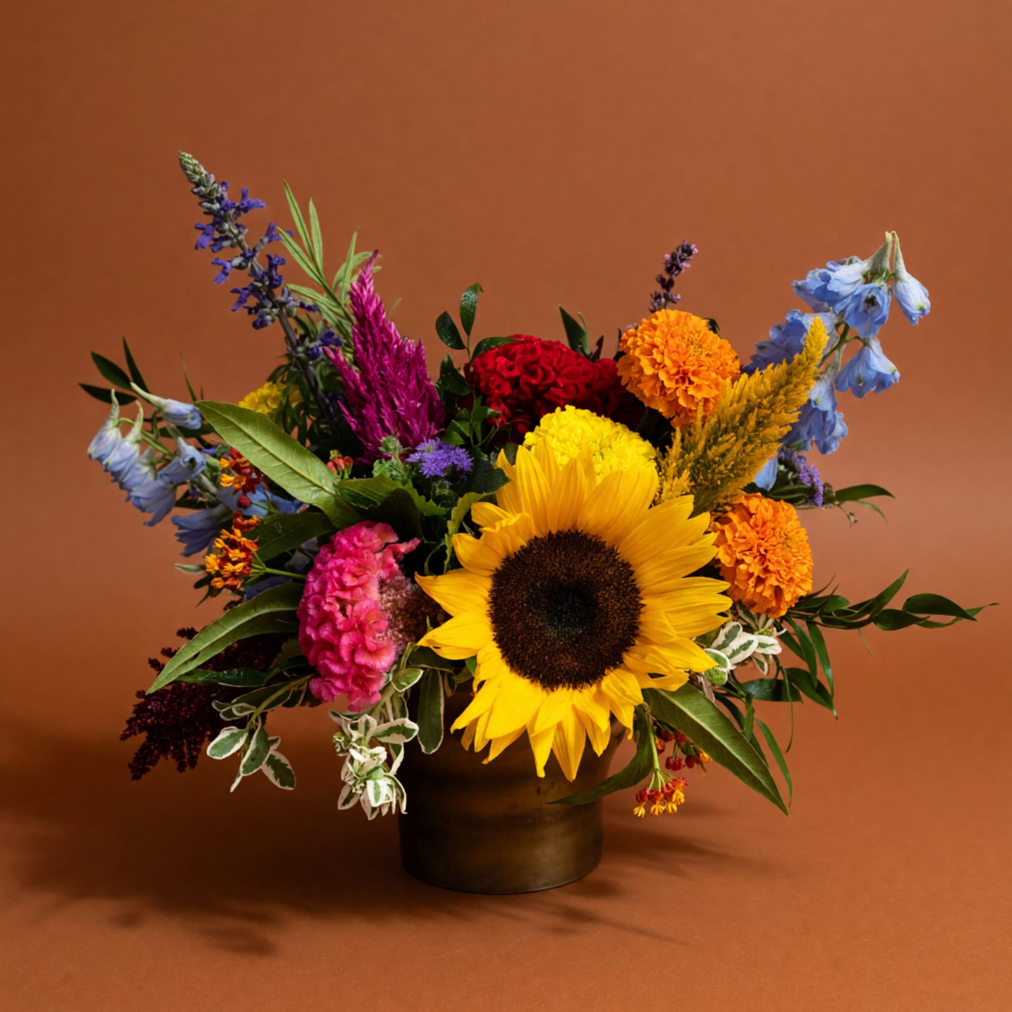 Colorful mixed bouquet with a sunflower in a dark vase