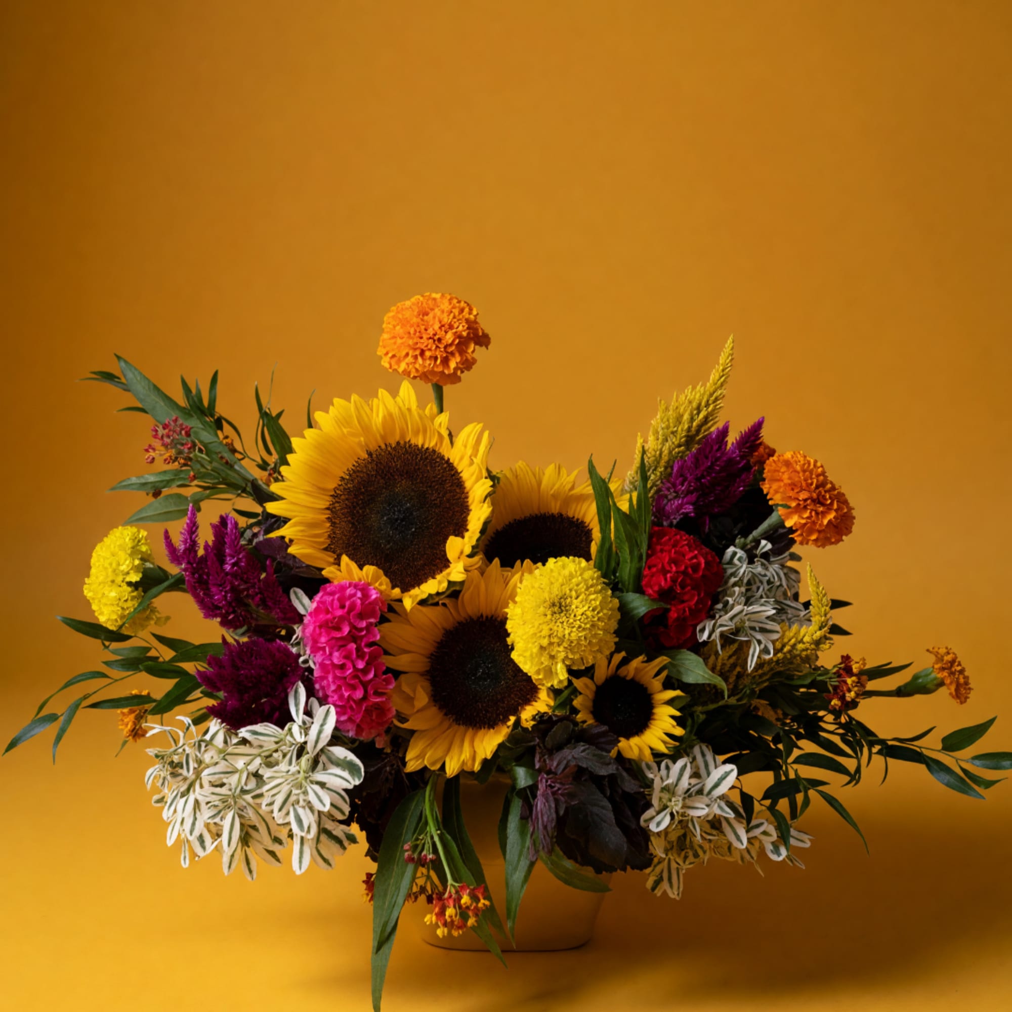 Mixed bouquet with sunflowers, marigolds, and colorful blooms in a vase