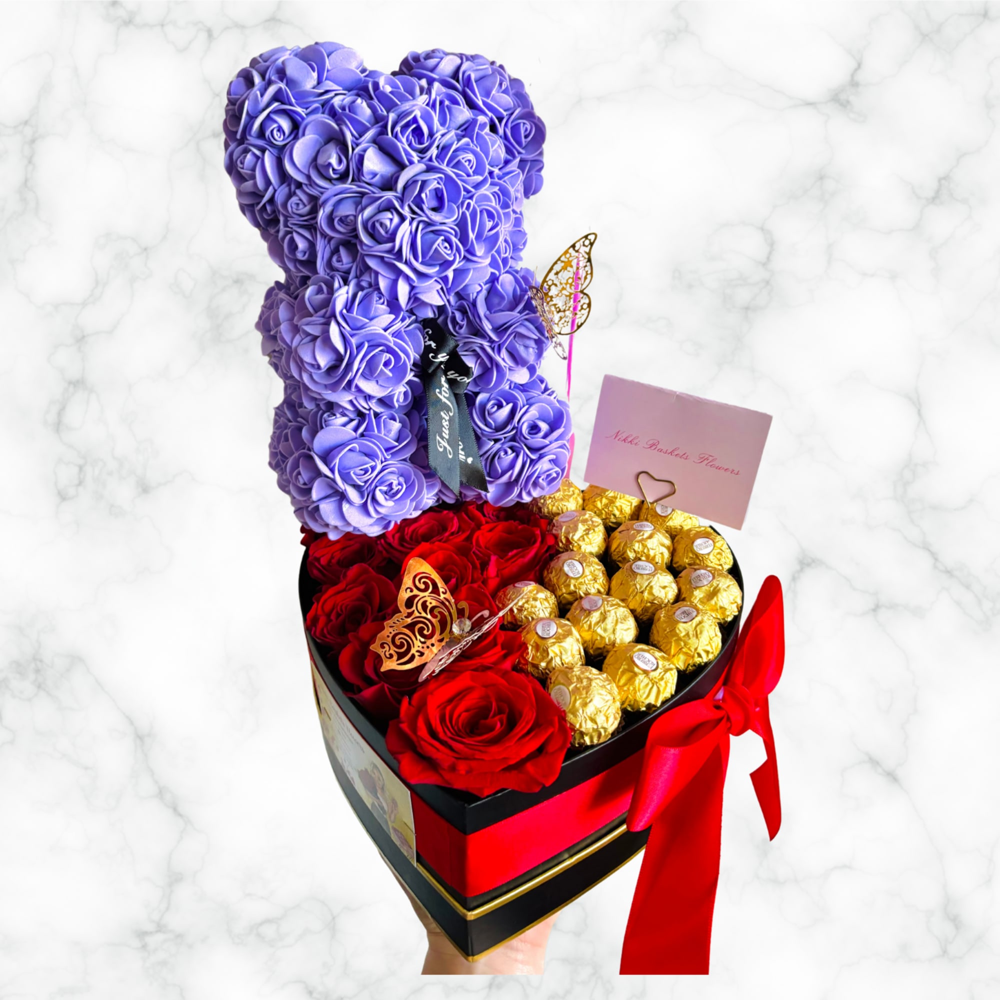Purple teddy bear made of roses in a heart box with red roses and chocolates