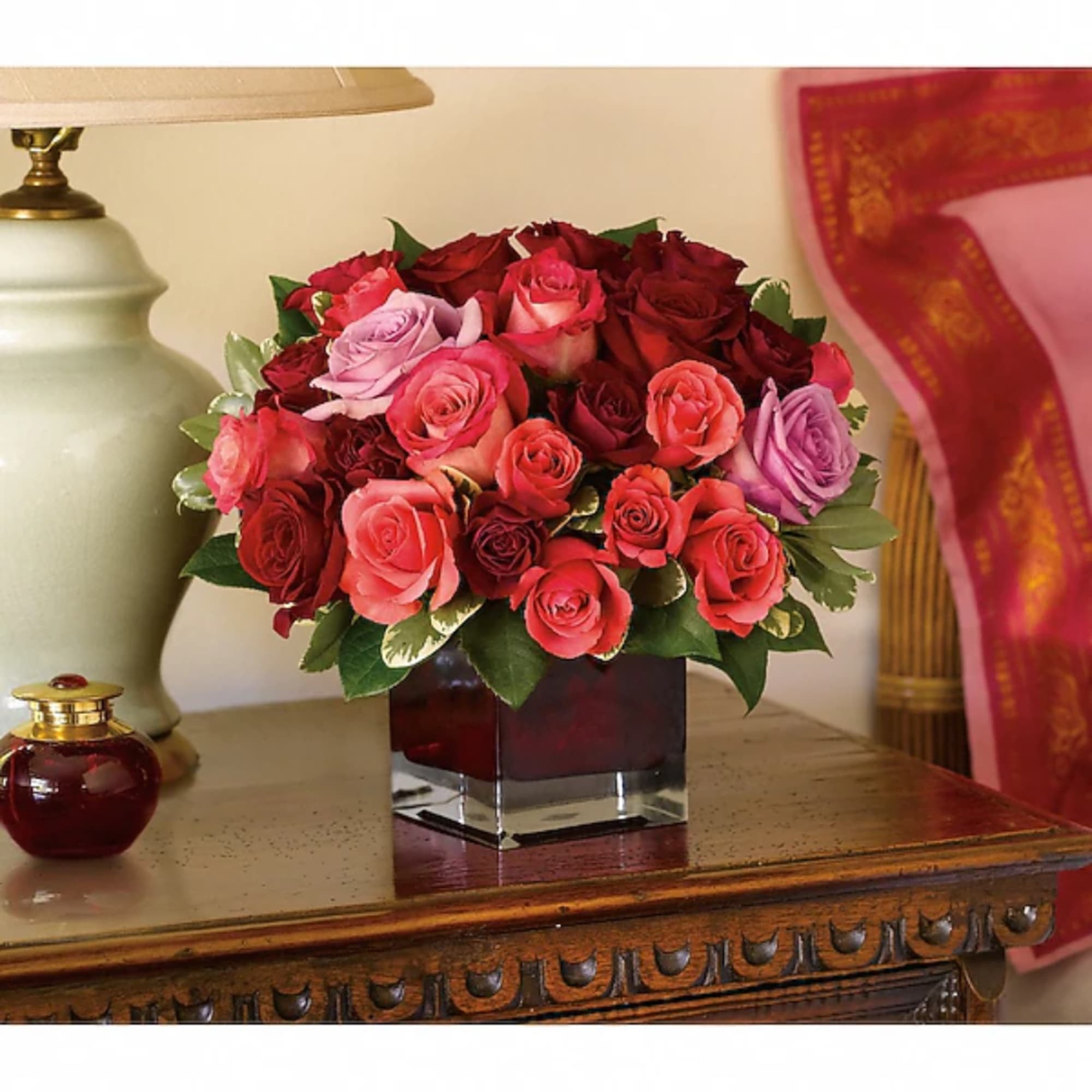 Mixed roses in a square glass vase on a wooden table
