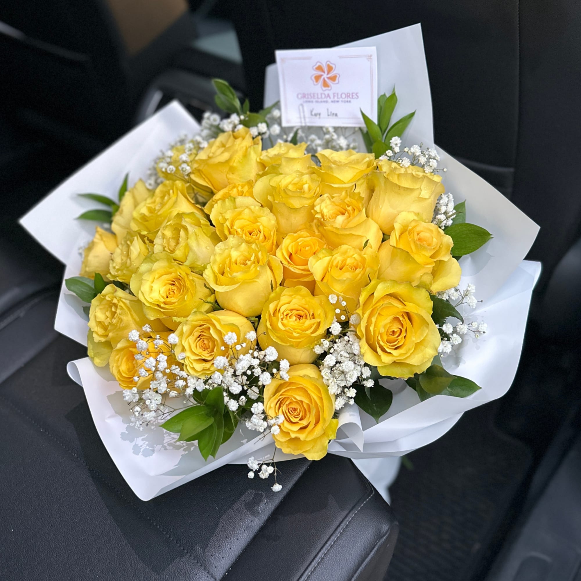 Bouquet of yellow roses with white baby's breath in white wrapping, photo 2 of 3