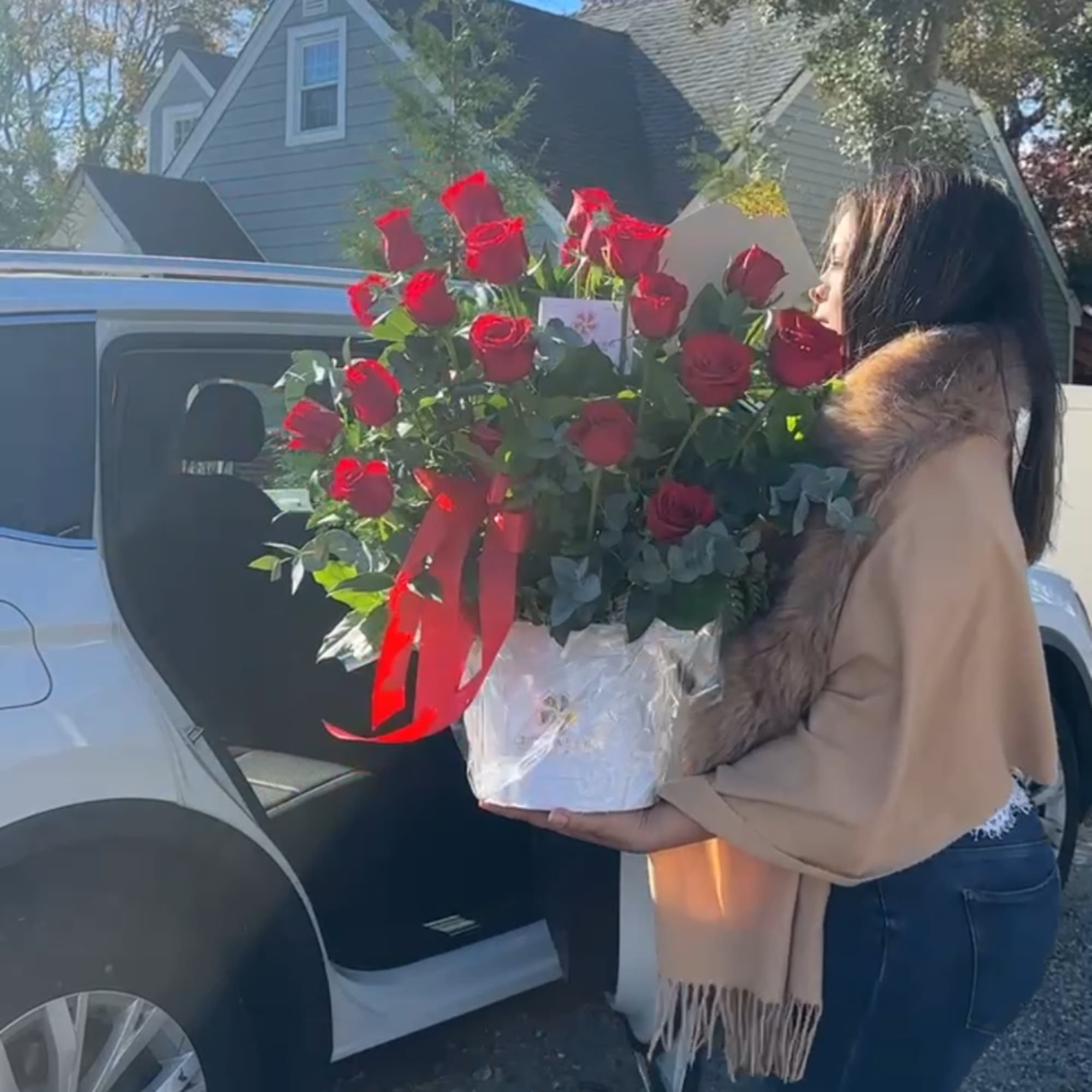 Large bouquet of red roses in a white hatbox with a red ribbon