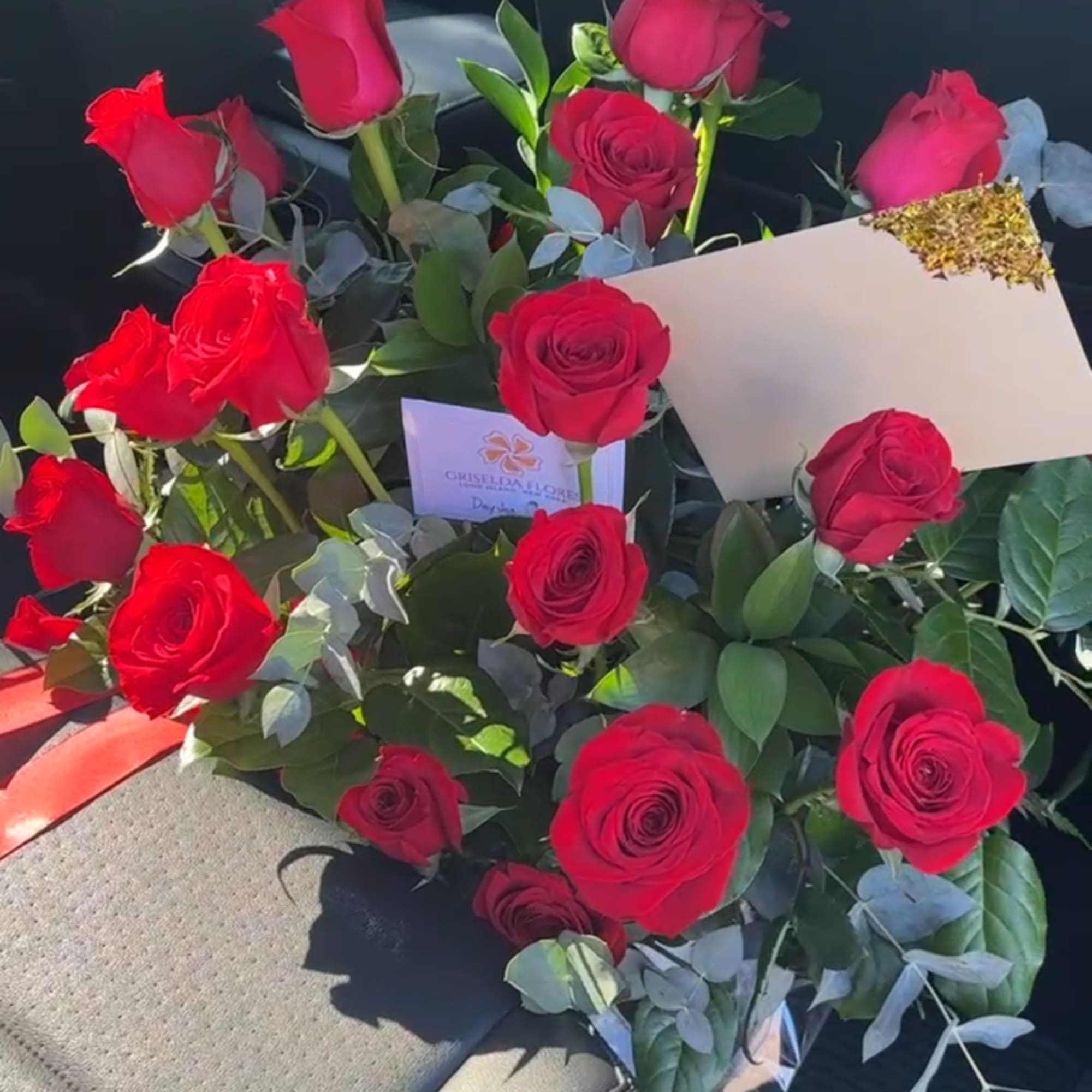 Bouquet of red roses with eucalyptus and a card
