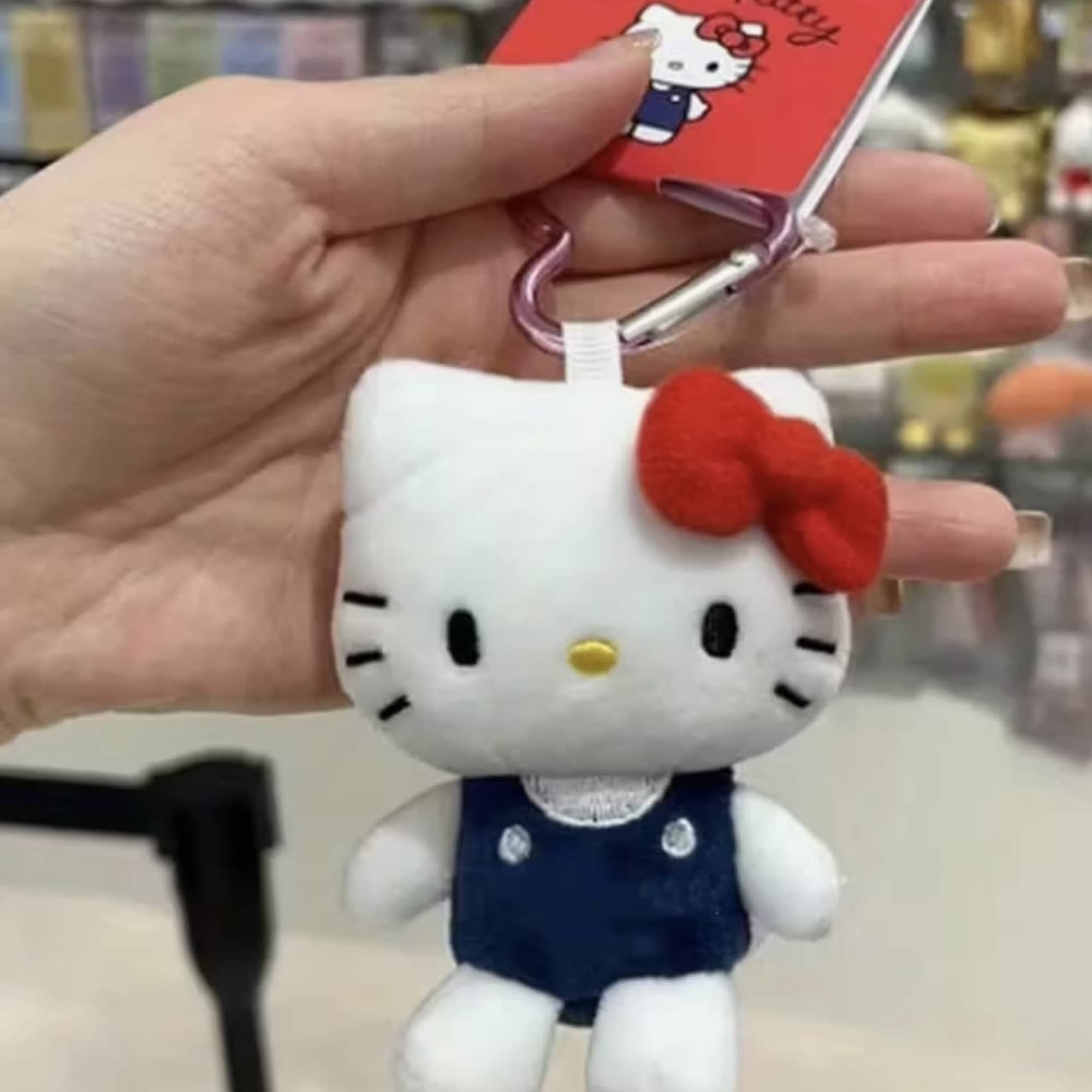 Hello Kitty plush keychain with a red bow and clip