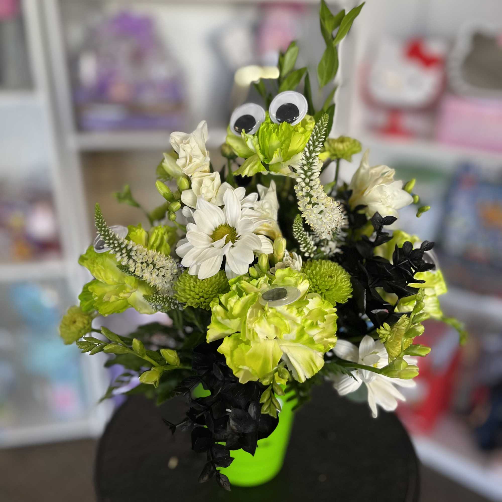 Bouquet of white and lime-green flowers in a bright green vase