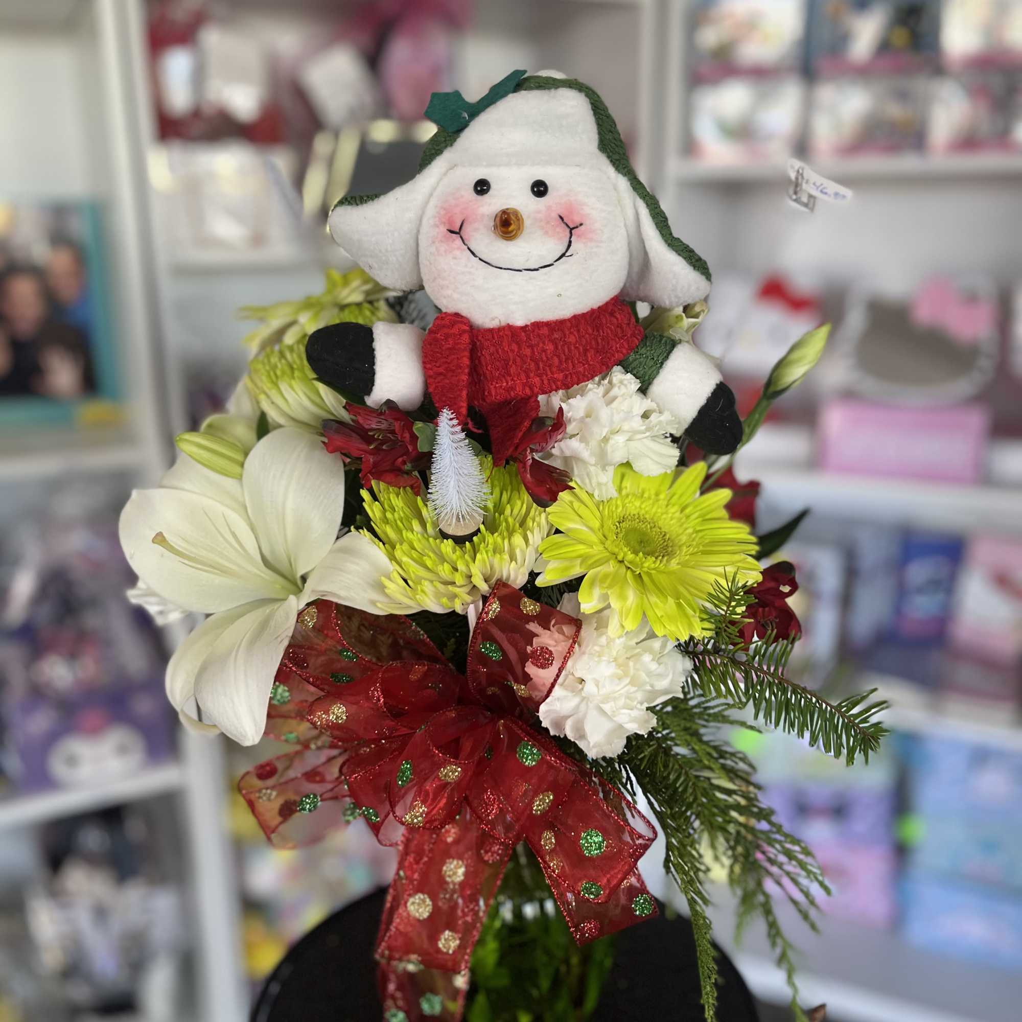Holiday bouquet with a snowman plush and white, red, and yellow flowers