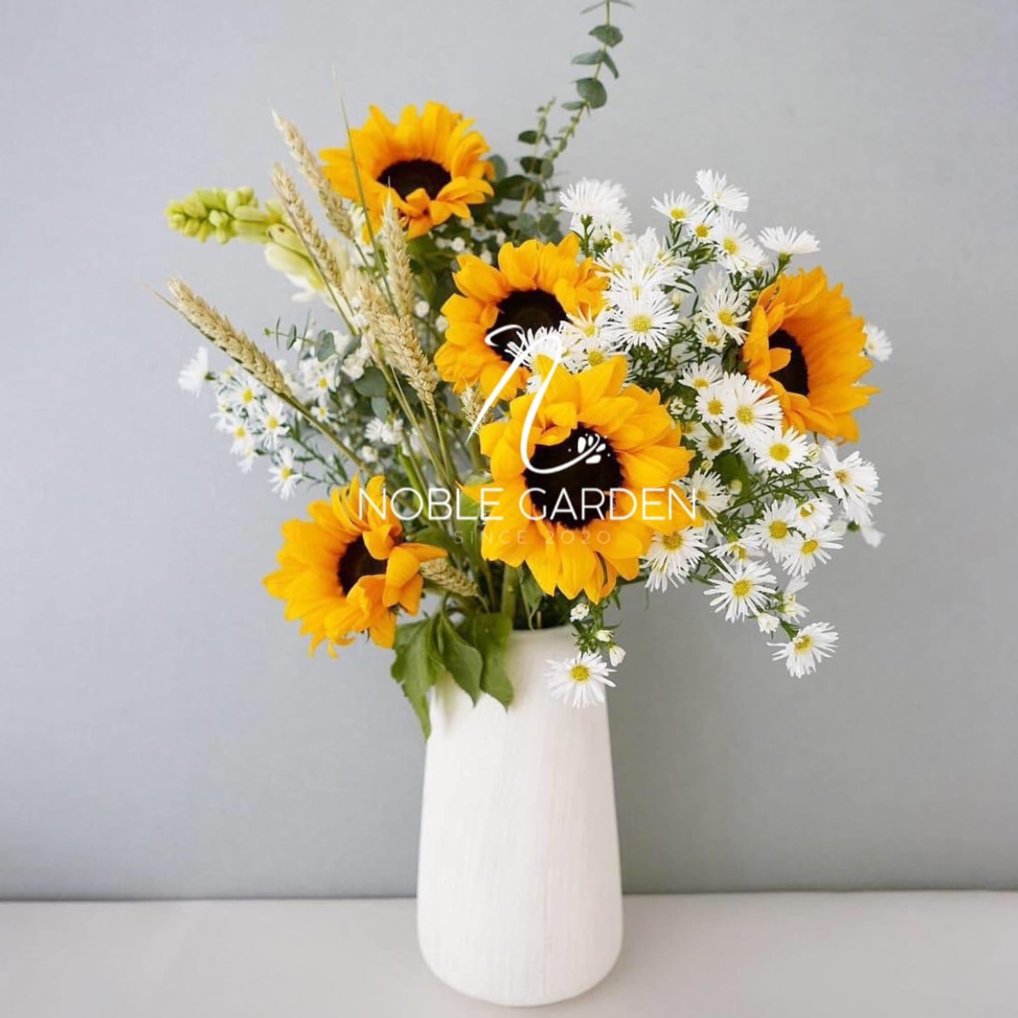 Sunflowers and white daisies in a white vase
