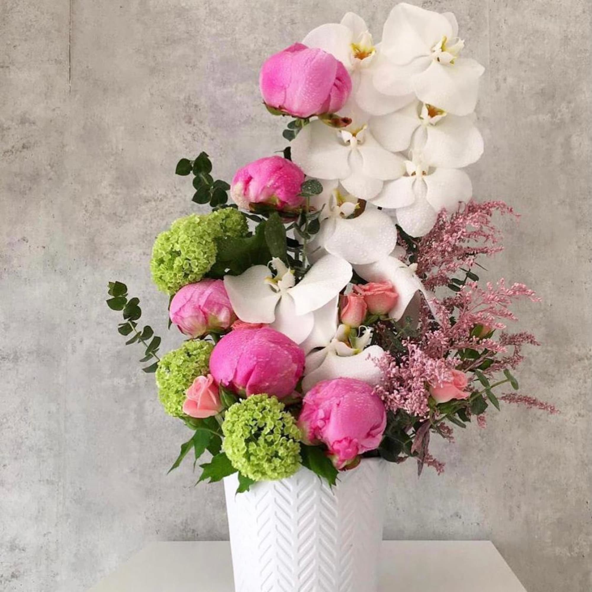 Pink and white floral arrangement in a white vase