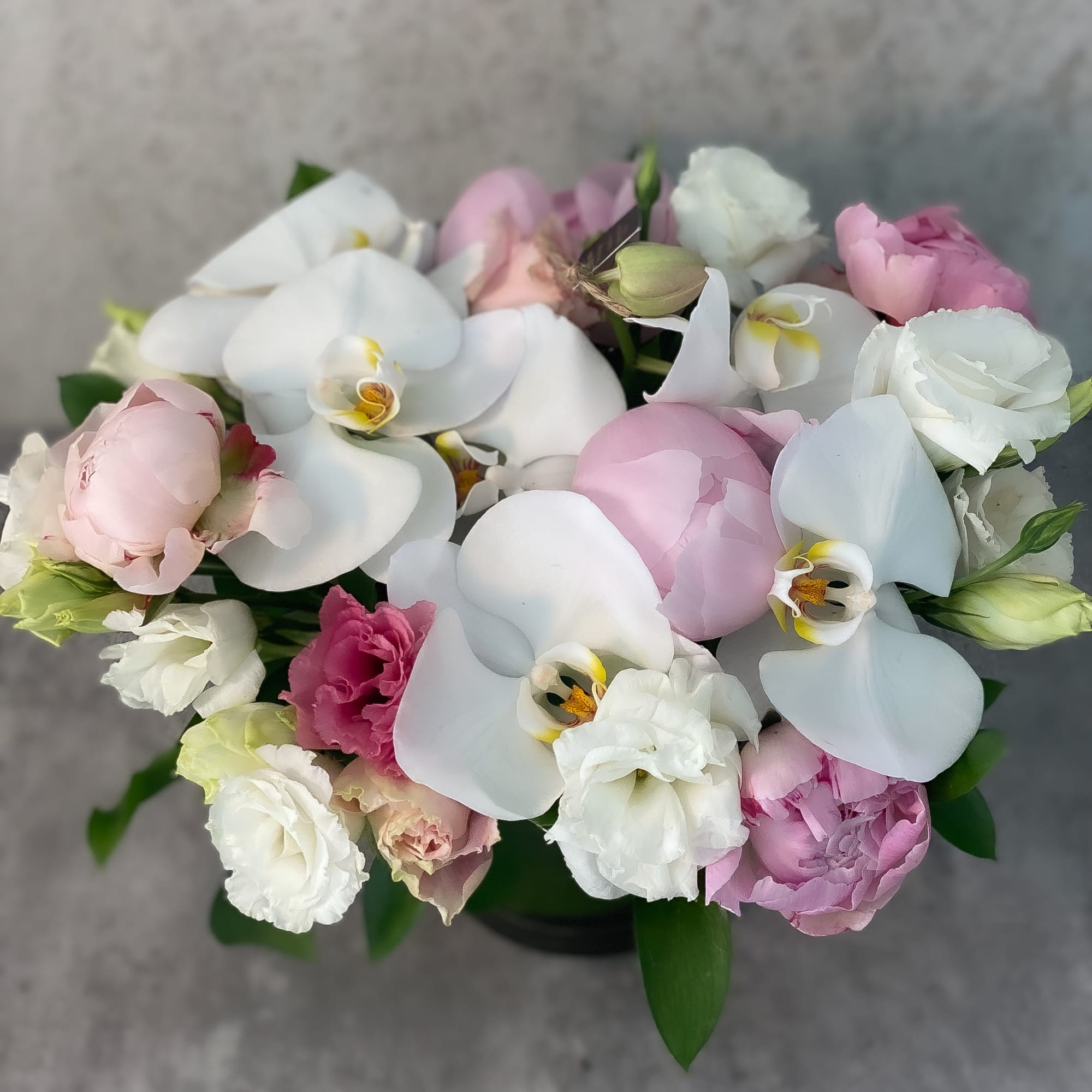 Bouquet of white orchids and pink flowers in a low arrangement