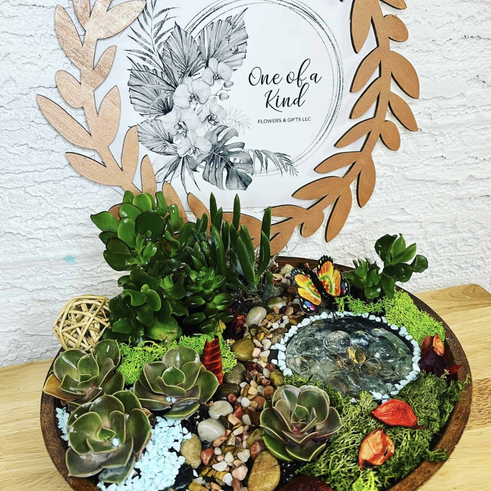 Succulent dish garden with a small water feature and decorative stones