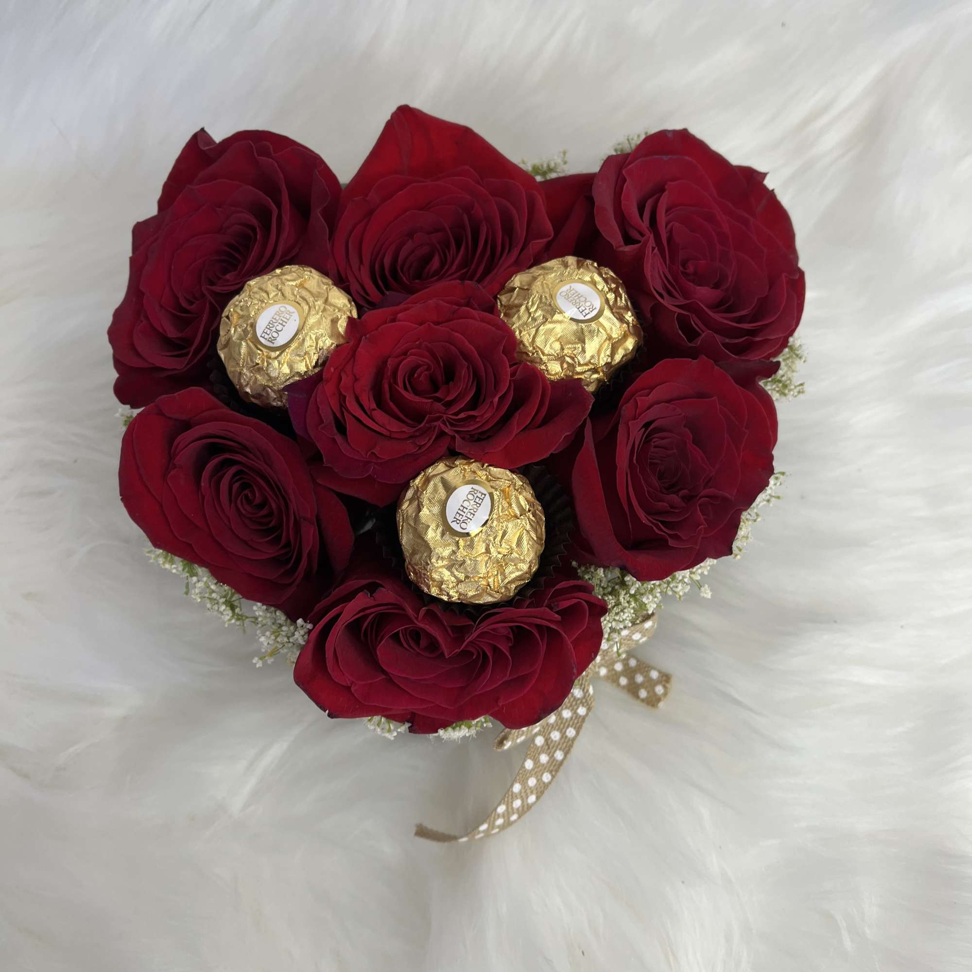 Heart-shaped bouquet of red roses with gold-wrapped chocolates