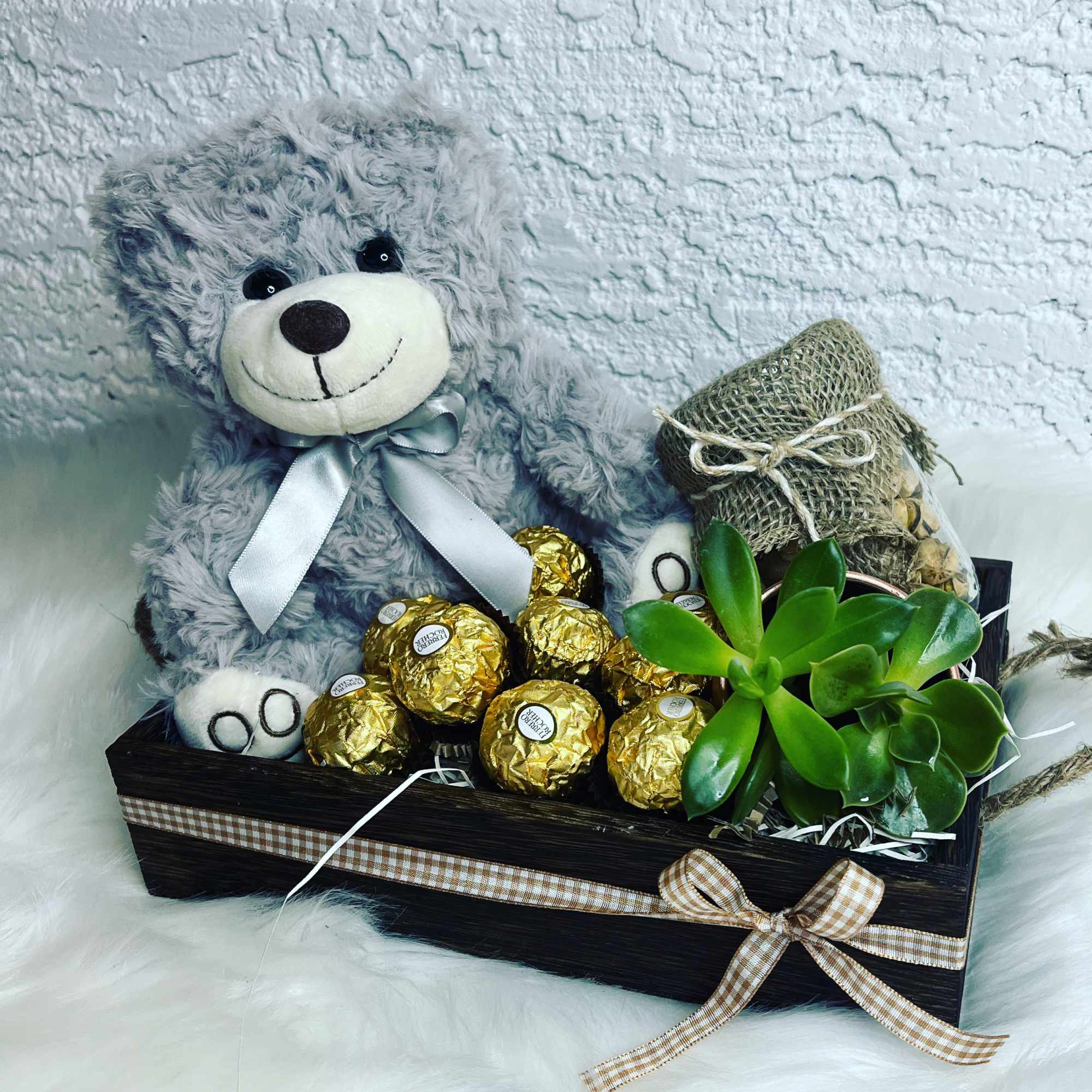 Teddy bear gift basket with chocolates and a succulent