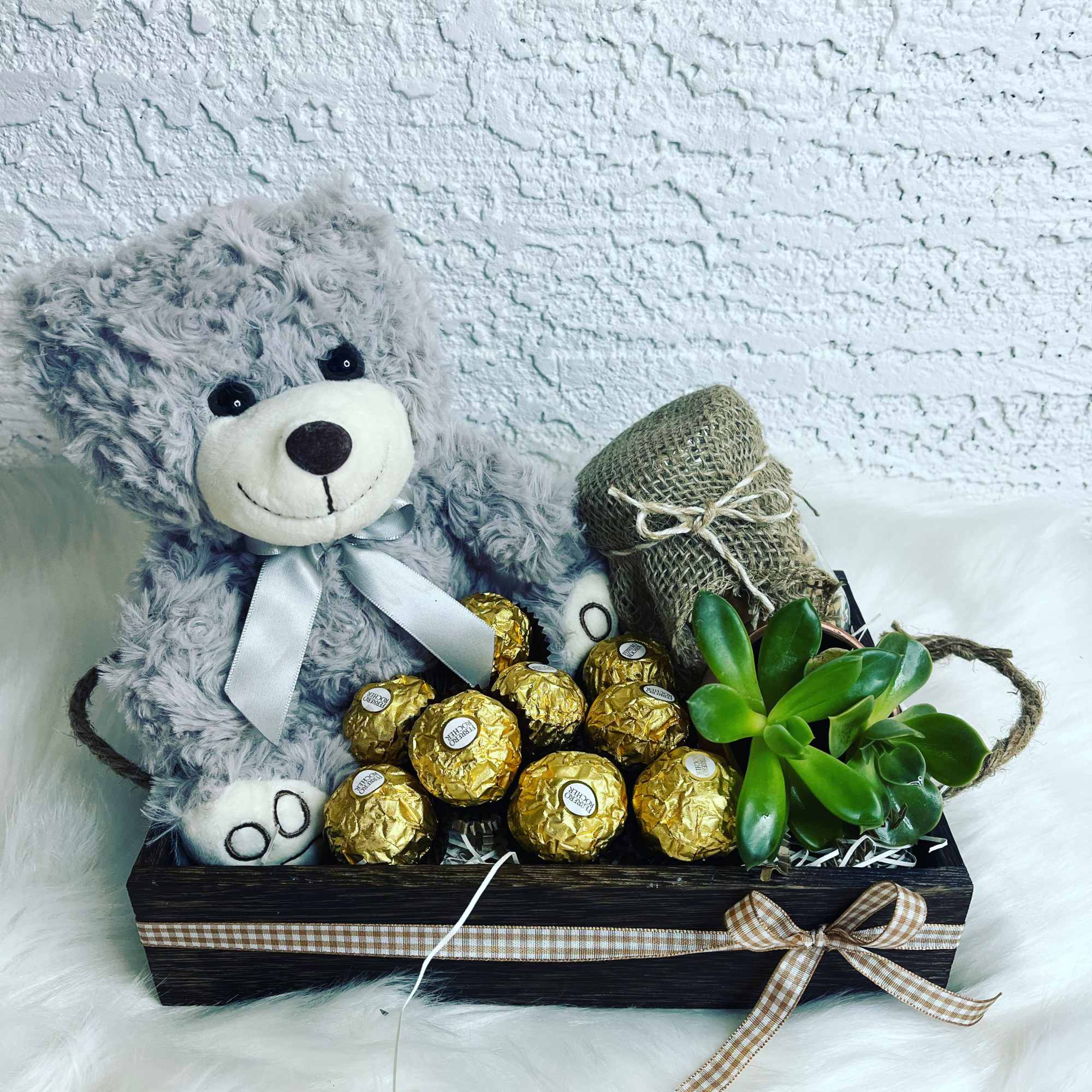 Teddy bear with chocolates and a small succulent in a gift box