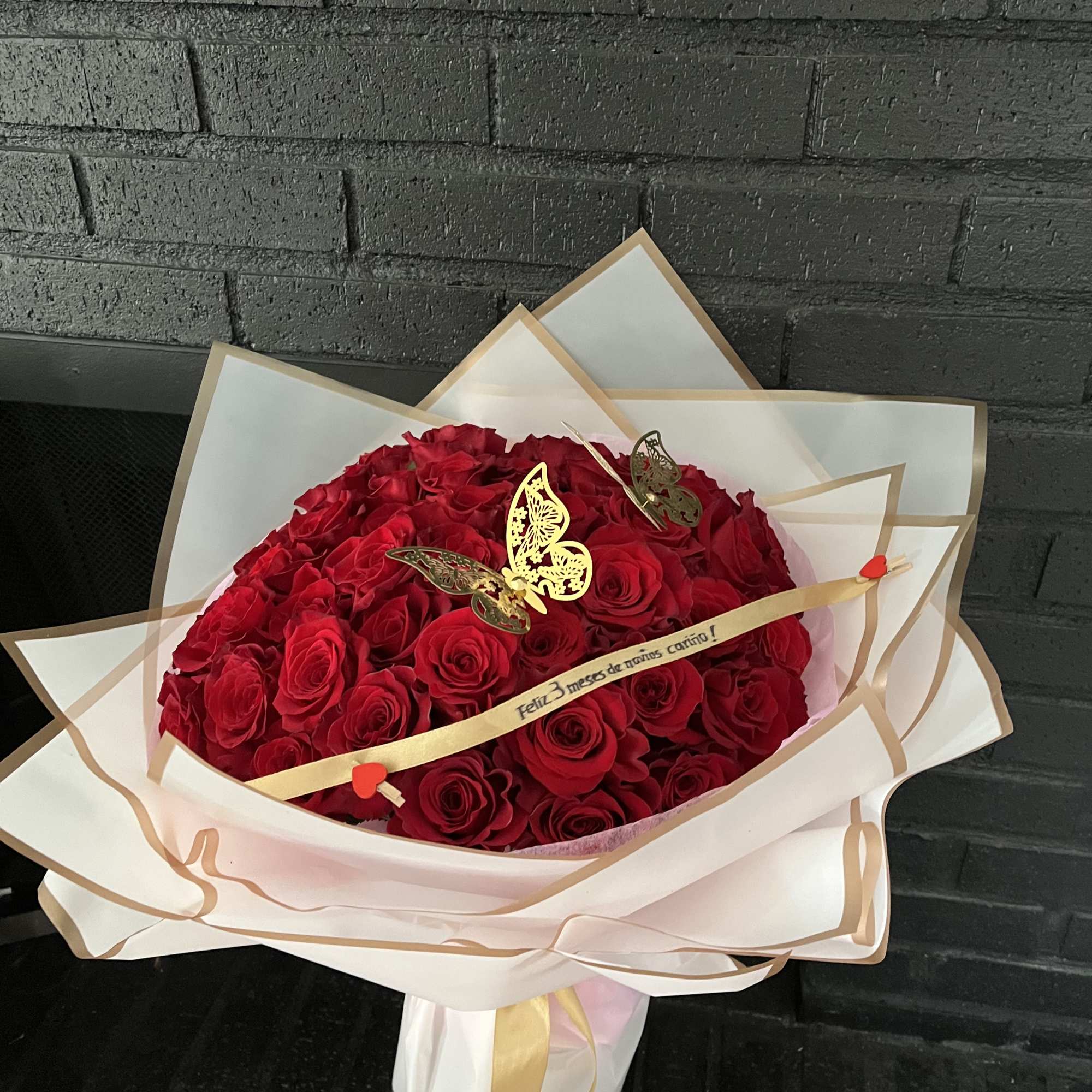 Large bouquet of red roses wrapped in white paper with gold trim, photo 2 of 5