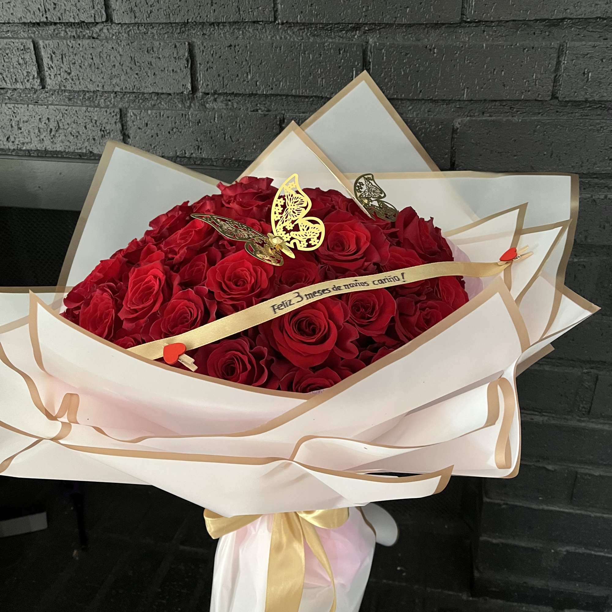 Large bouquet of red roses wrapped in white paper with gold trim, photo 5 of 5