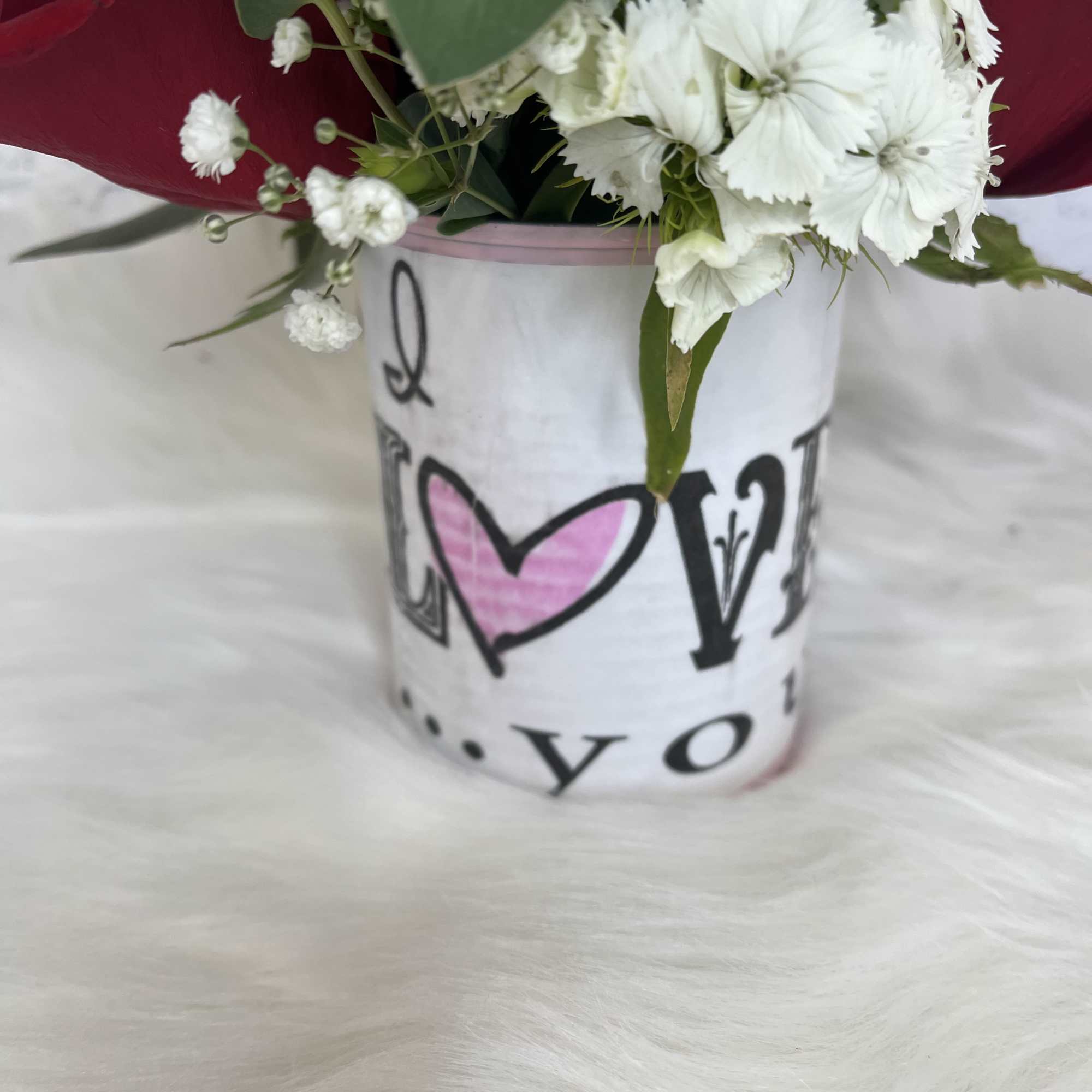 White flowers in a decorative bucket with pink wrapping