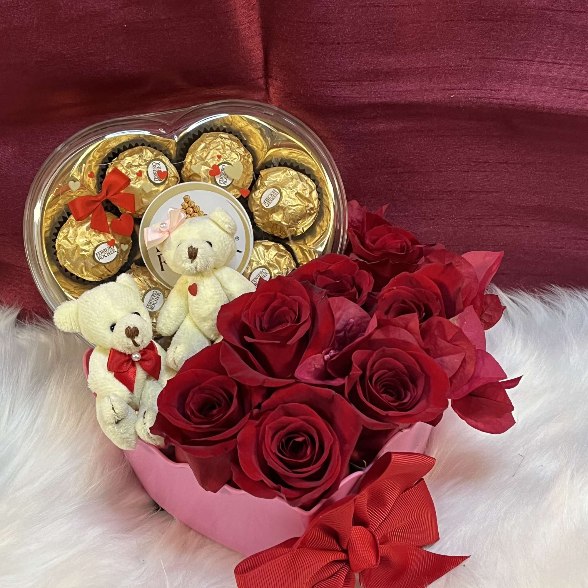 Heart-shaped gift box with red roses, chocolates, and two teddy bears