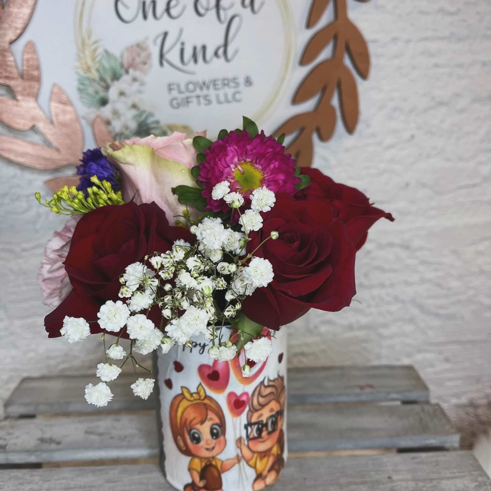 Bouquet of red roses with white baby's breath in a decorated cup