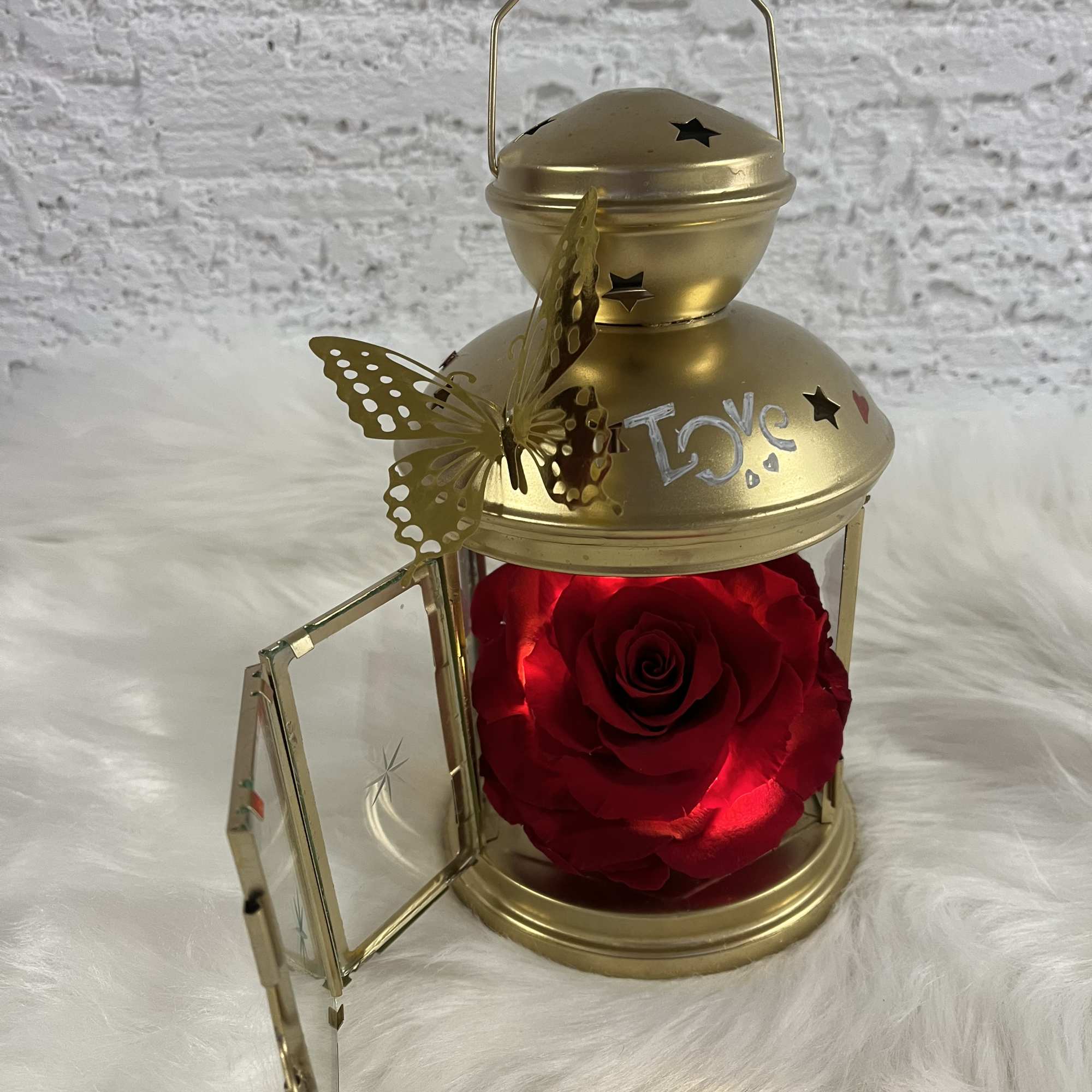 Gold lantern with a red rose inside and a butterfly decoration