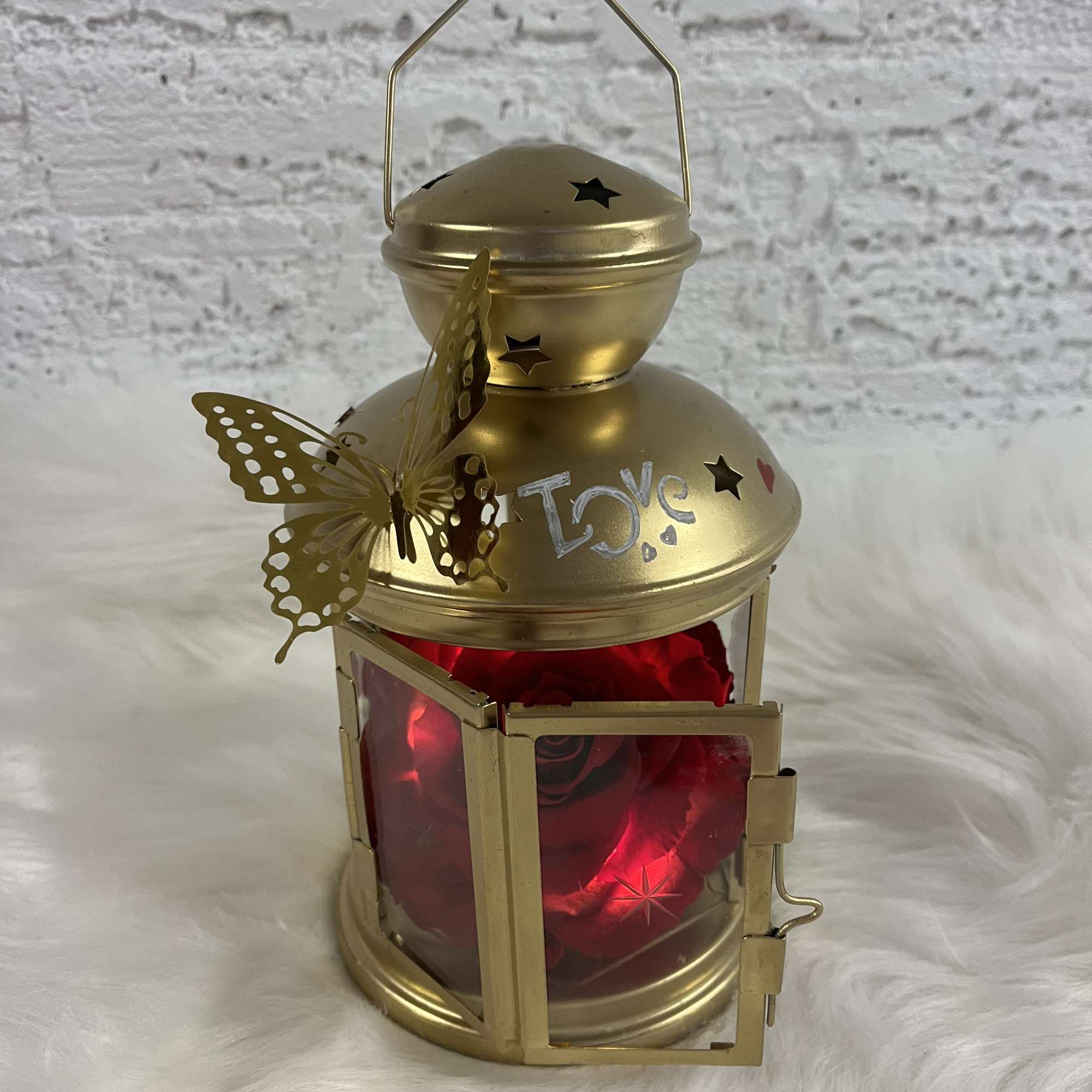 Gold lantern with red roses inside and a butterfly decoration