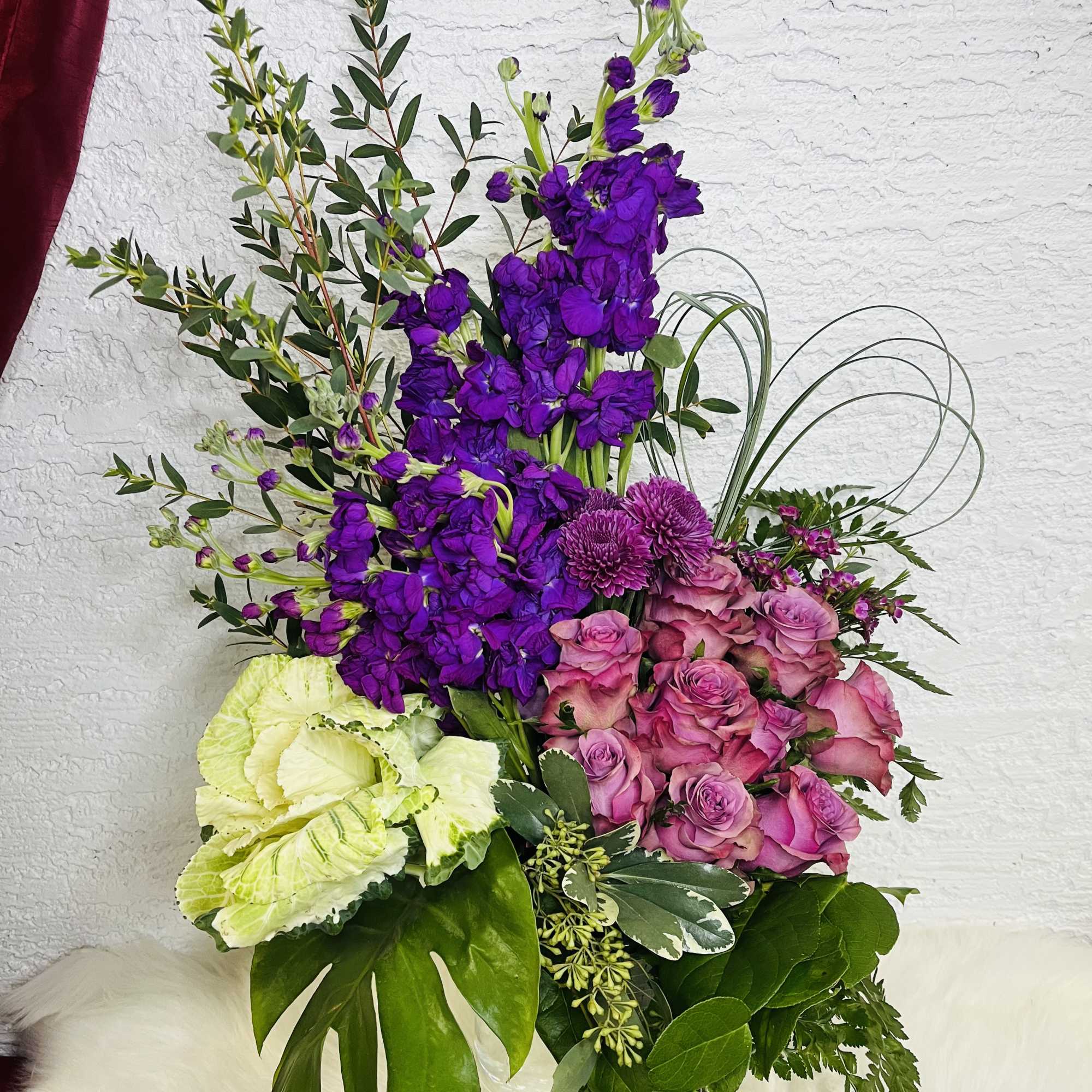 Purple and pink floral arrangement in a clear glass vase