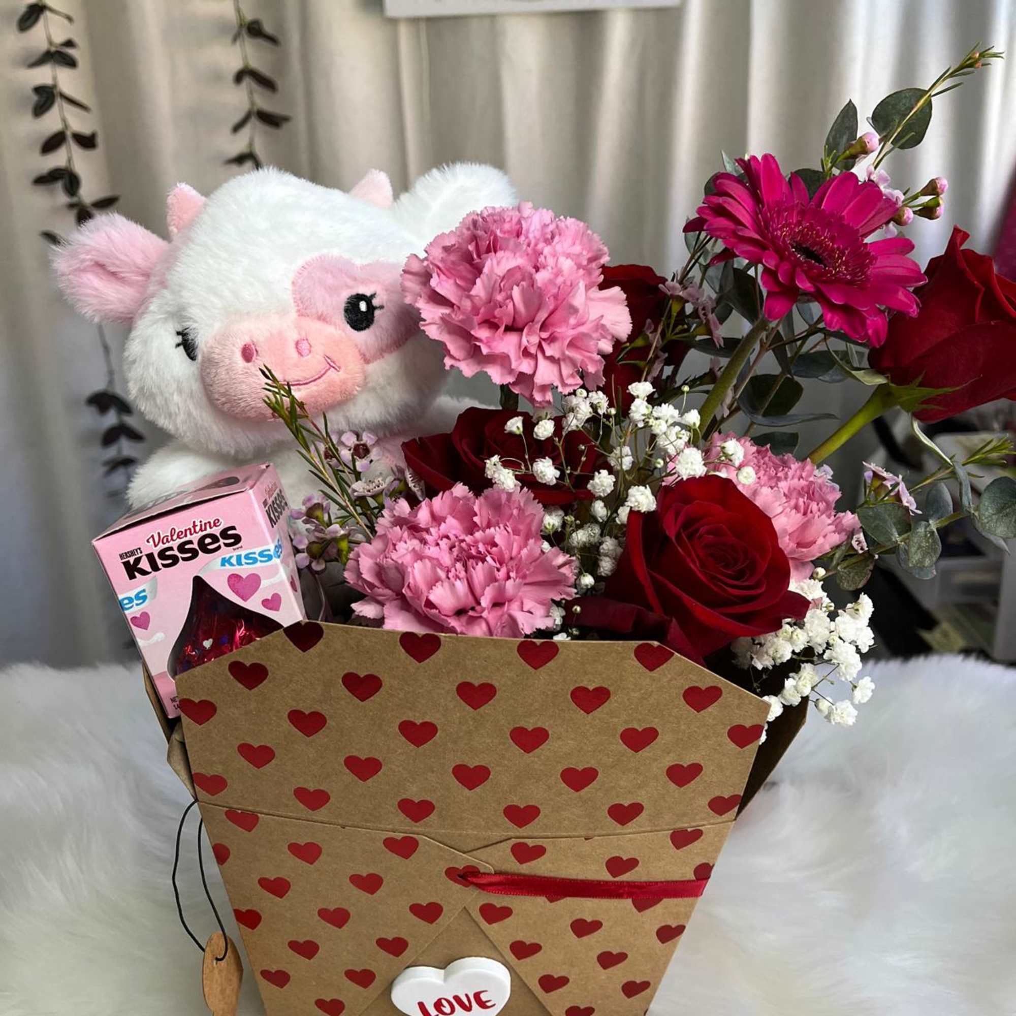 Bouquet of red roses and pink carnations with a plush pig and candy box