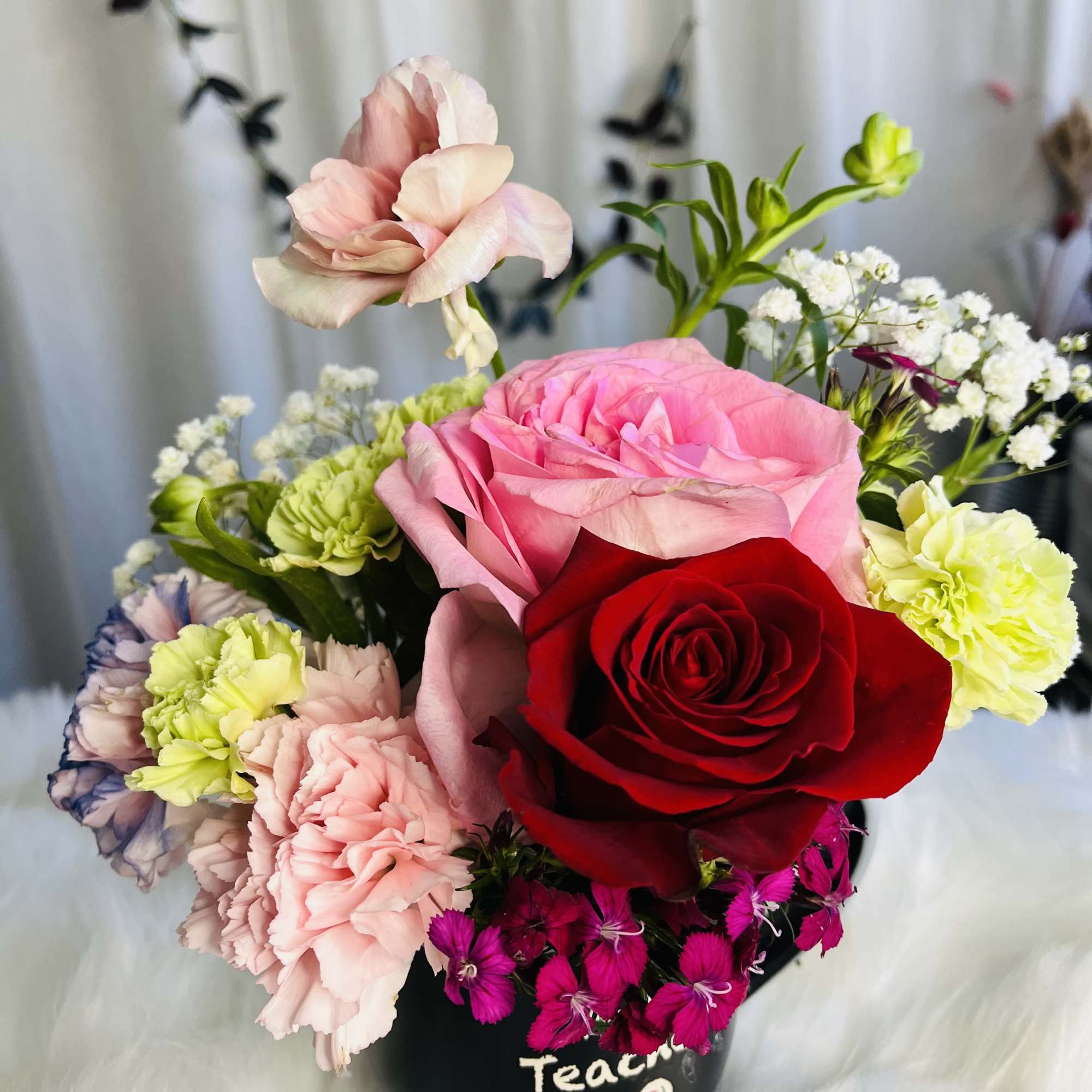 Mixed bouquet in a black vase with pink and red roses